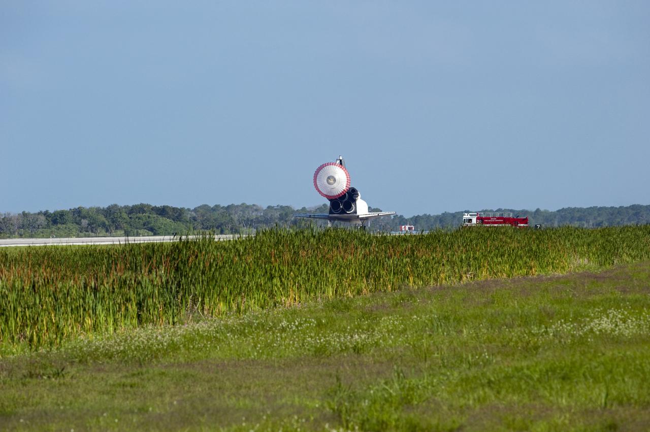 CAPE CANAVERAL, Fla. - Space shuttle Atlantis rolls to a stop as NASA's Fire Emergency Services vehicle approaches Runway 33 at the Shuttle Landing Facility at NASA's Kennedy Space Center in Florida. The emergency vehicle is part of a long convoy that greets every shuttle upon return to Earth. Landing was at 8:48 a.m. EDT, completing the 12-day STS-132 mission to the International Space Station.  The six-member STS-132 crew carried the Russian-built Mini Research Module-1 to the space station. STS-132 is the 34th shuttle mission to the station, the 132nd shuttle mission overall and the last planned flight for Atlantis. For information on the STS-132 mission and crew, visit www.nasa.gov_mission_pages_shuttle_shuttlemissions_sts132_index.html. Photo credit: NASA_Tom Joseph