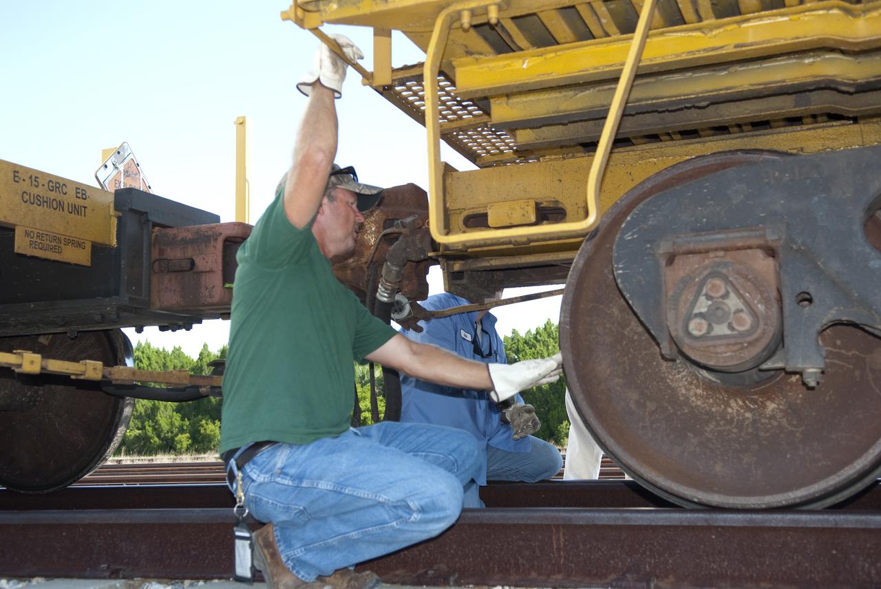 CAPE CANAVERAL, Fla. - At the Jay Jay Rail Yard in Titusville, Fla., a NASA Railroad mechanic checks out the brakes on a Union Pacific rail car carrying one of the last space shuttle solid rocket booster segments. The NASA train will transport the segments on the last leg of their journey into NASA's Kennedy Space Center. Six cars transported the segments along the Florida East Coast Railway, which began at the ATK solid rocket booster plant in Promontory, Utah.   The booster segments will be used for shuttle Atlantis on what currently is planned as the 'launch on need,' or potential rescue mission for the final shuttle flight, Endeavour's STS-134 mission.  For information, visit www.nasa.gov_shuttle. Photo credit: NASA_Jim Grossmann