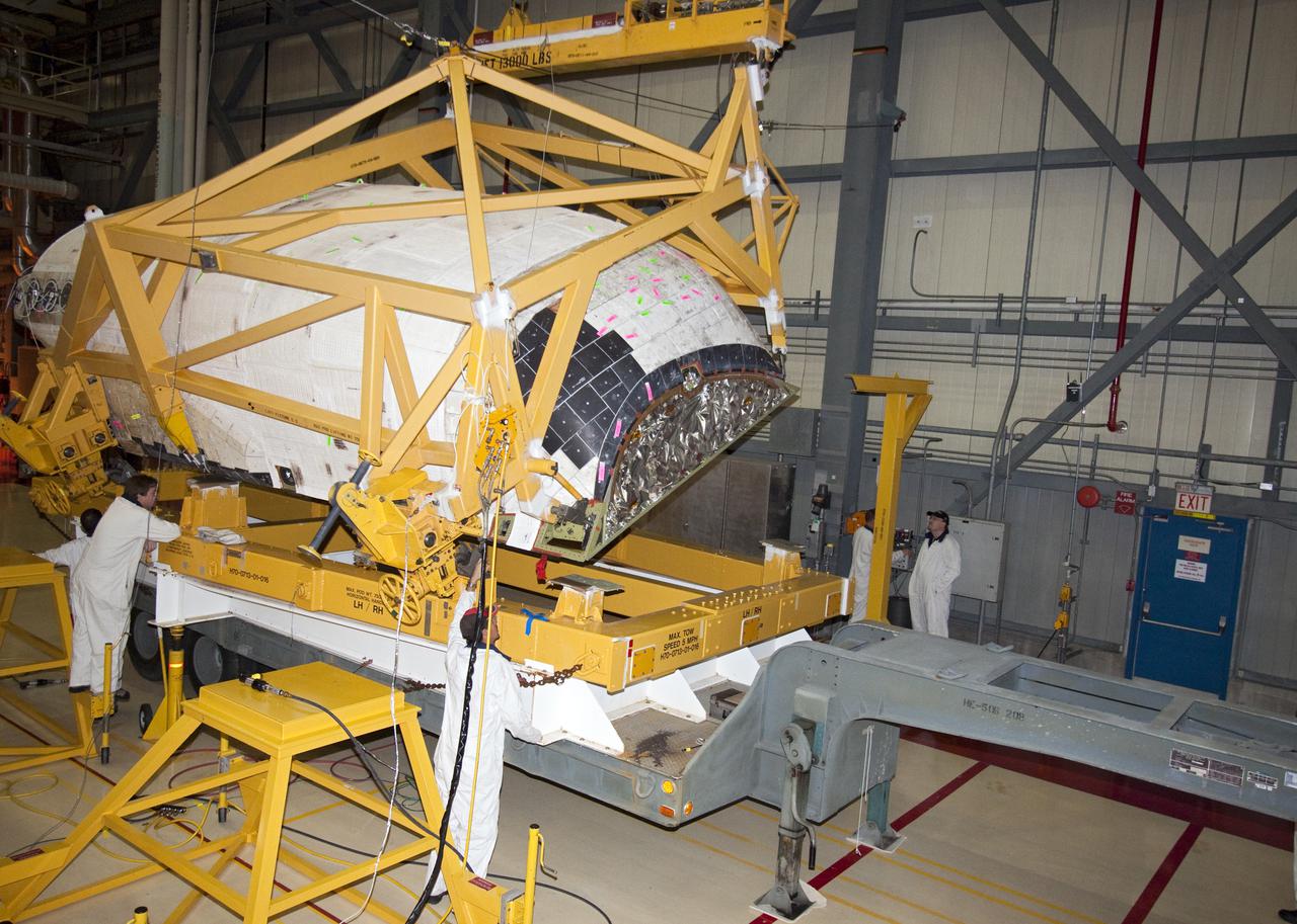 CAPE CANAVERAL, Fla. – Inside Orbiter Processing Facility-3 at Kennedy Space Center in Florida, United Space Alliance technicians place the right-hand orbital maneuvering system, or OMS, pod from Discovery on a pallet to be transferred to the Hypergolic Maintenance Facility. Removal of the OMS pods is part of the orbiter processing activities to prepare Discovery for its next launch, the STS-133 mission. The STS-133 mission to the International Space Station is targeted for launch in the fall of 2010. Discovery’s six-person crew will take important spare parts to the International Space Station along with the Express Logistics Carrier 4. Photo credit: NASA_Jack Pfaller