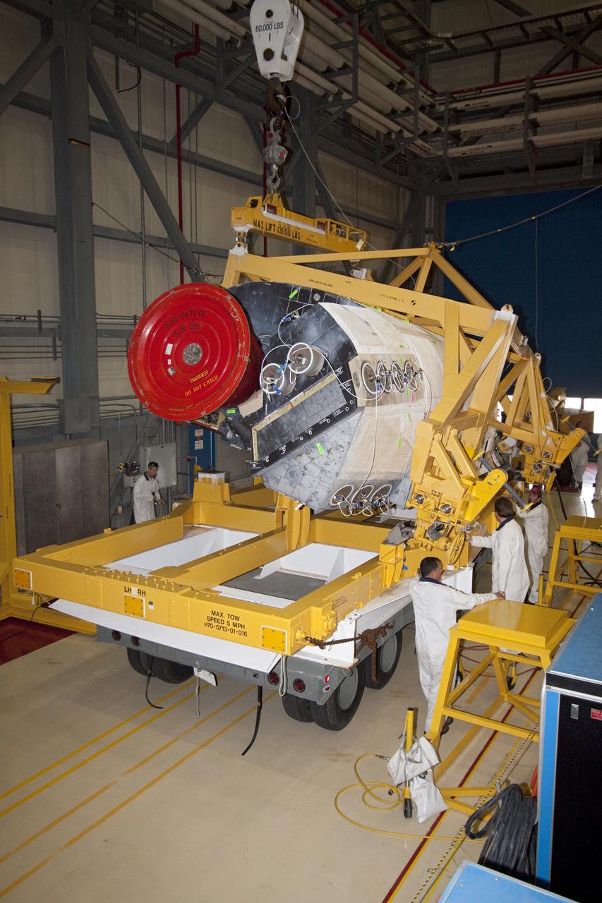 CAPE CANAVERAL, Fla. – Inside Orbiter Processing Facility-3 at Kennedy Space Center in Florida, United Space Alliance technicians place the right-hand orbital maneuvering system, or OMS, pod from Discovery on a pallet to be transferred to the Hypergolic Maintenance Facility. Removal of the OMS pods is part of the orbiter processing activities to prepare Discovery for its next launch, the STS-133 mission. The STS-133 mission to the International Space Station is targeted for launch in the fall of 2010. Discovery’s six-person crew will take important spare parts to the International Space Station along with the Express Logistics Carrier 4. Photo credit: NASA_Jack Pfaller
