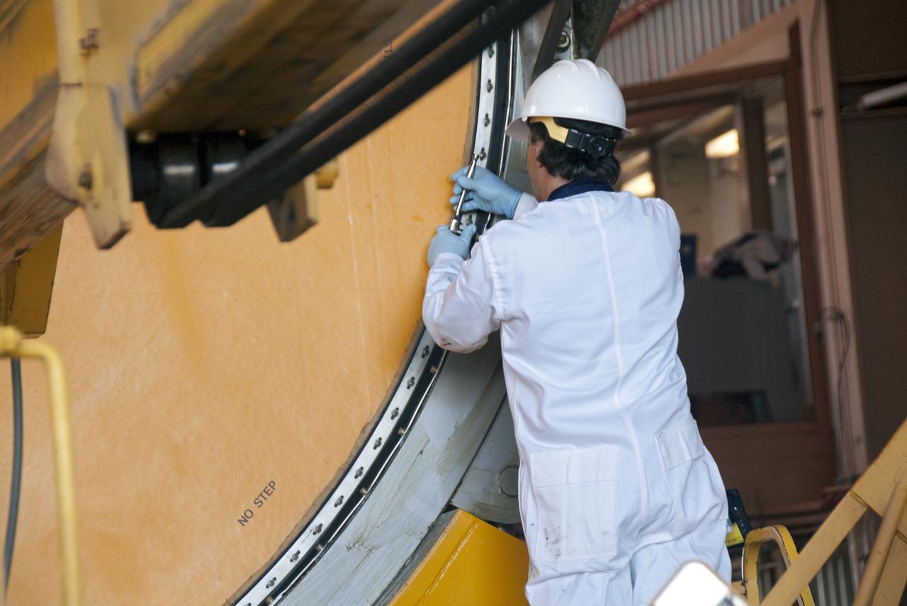CAPE CANAVERAL, Fla. -- In the Rotation, Processing and Surge Facility, or RSPF, at NASA's Kennedy Space Center in Florida, a worker makes sure the final solid rocket booster segments are level, balanced and concentric, which is a required safety analysis. Workers also will perform a propellant grain inspection. The booster segments were manufactured at the ATK solid rocket booster plant in Promontory, Utah, and traveled to Kennedy along the Florida East Coast Railway.  The booster segments will be stacked and then mated to space shuttle Atlantis and its external fuel tank in the Vehicle Assembly Building. The segments will be used for what currently is planned as the 'launch on need,' or potential rescue mission for the final shuttle flight, Endeavour's STS-134 mission. For information, visit www.nasa.gov_shuttle. Photo credit: NASA_Cory Huston