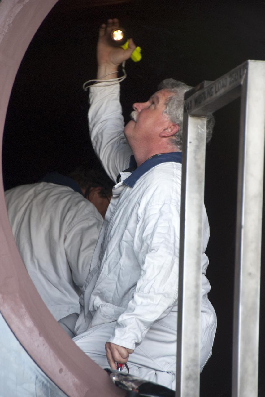CAPE CANAVERAL, Fla. -- In the Rotation, Processing and Surge Facility, or RSPF, at NASA's Kennedy Space Center in Florida, a worker performs the propellant grain inspection of the final solid rocket booster segments, which is a required safety analysis. The booster segments were manufactured at the ATK solid rocket booster plant in Promontory, Utah, and traveled to Kennedy along the Florida East Coast Railway.  The booster segments will be stacked and then mated to space shuttle Atlantis and its external fuel tank in the Vehicle Assembly Building. The segments will be used for what currently is planned as the 'launch on need,' or potential rescue mission for the final shuttle flight, Endeavour's STS-134 mission. For information, visit www.nasa.gov_shuttle. Photo credit: NASA_Cory Huston