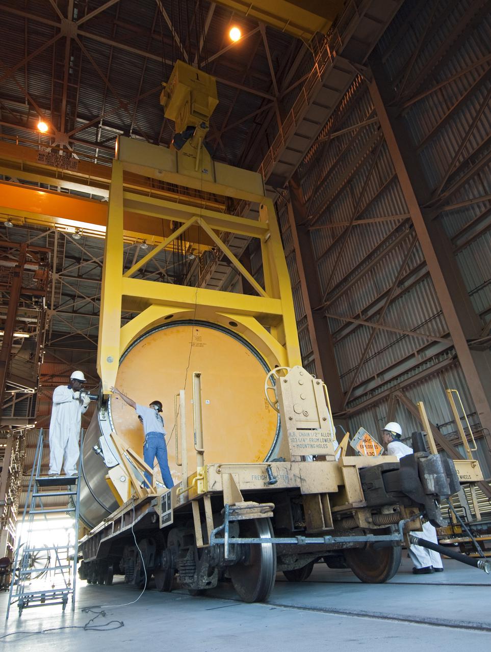 CAPE CANAVERAL, Fla. - At NASA's Kennedy Space Center in Florida, workers connect the solid rocket booster segment to two overhead cranes in the Rotation, Processing and Surge Facility.   The segments will be used for space shuttle  Atlantis on what currently is planned as the 'launch on need,' or potential rescue mission for the final shuttle flight, Endeavour's STS-134 mission. For information, visit www.nasa.gov_shuttle. Photo credit: NASA_Cory Huston