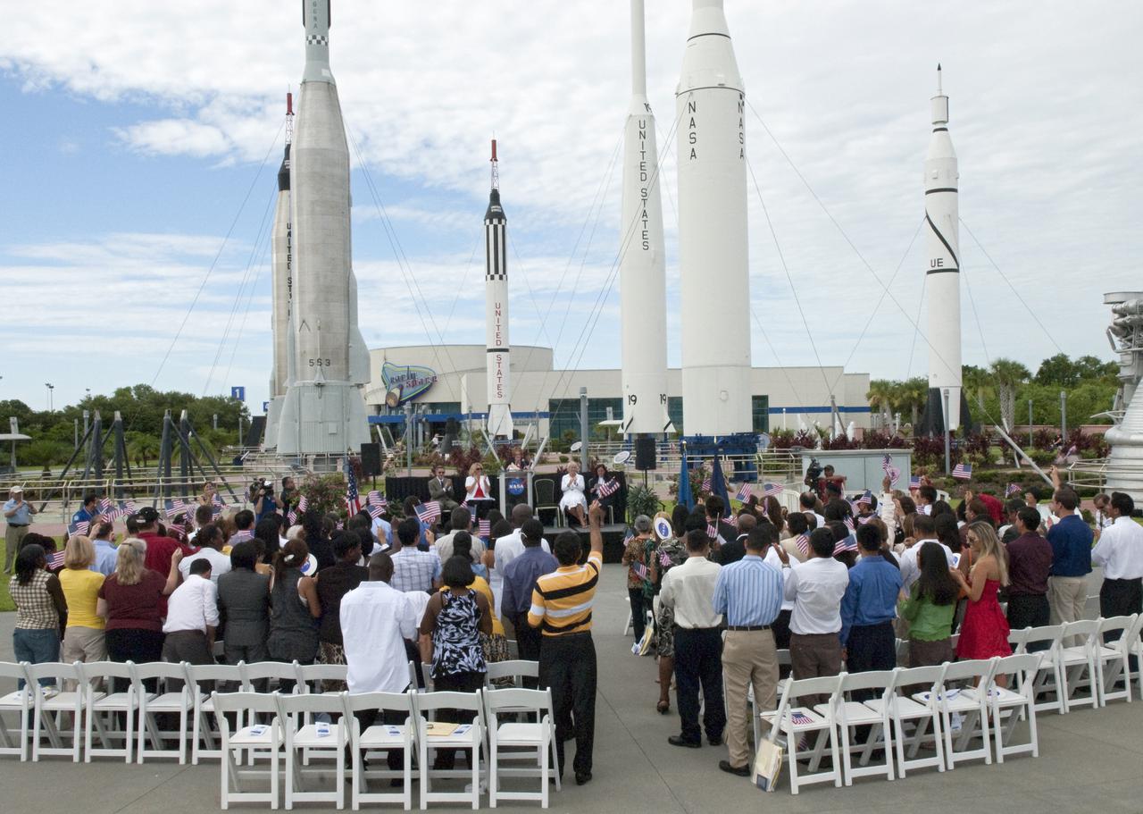 CAPE CANAVERAL, Fla. – At the Kennedy Space Center Visitor Complex in Florida, 110 people from 36 countries wave their American flags after taking the Oath of Allegiance to become American citizens. U.S. Citizenship and Immigration Services' Acting Southeast Regional Director Rosemary Langley Melville administered the oath in the complex's Rocket Garden in honor of the upcoming Independence Day holiday.   This was the first naturalization ceremony hosted by a NASA facility. An estimated 3,800 candidates will become citizens at 55 special ceremonies, including the one at Kennedy, held across the country and around the world July 1-6. Photo Credit: NASA_Jim Grossmann