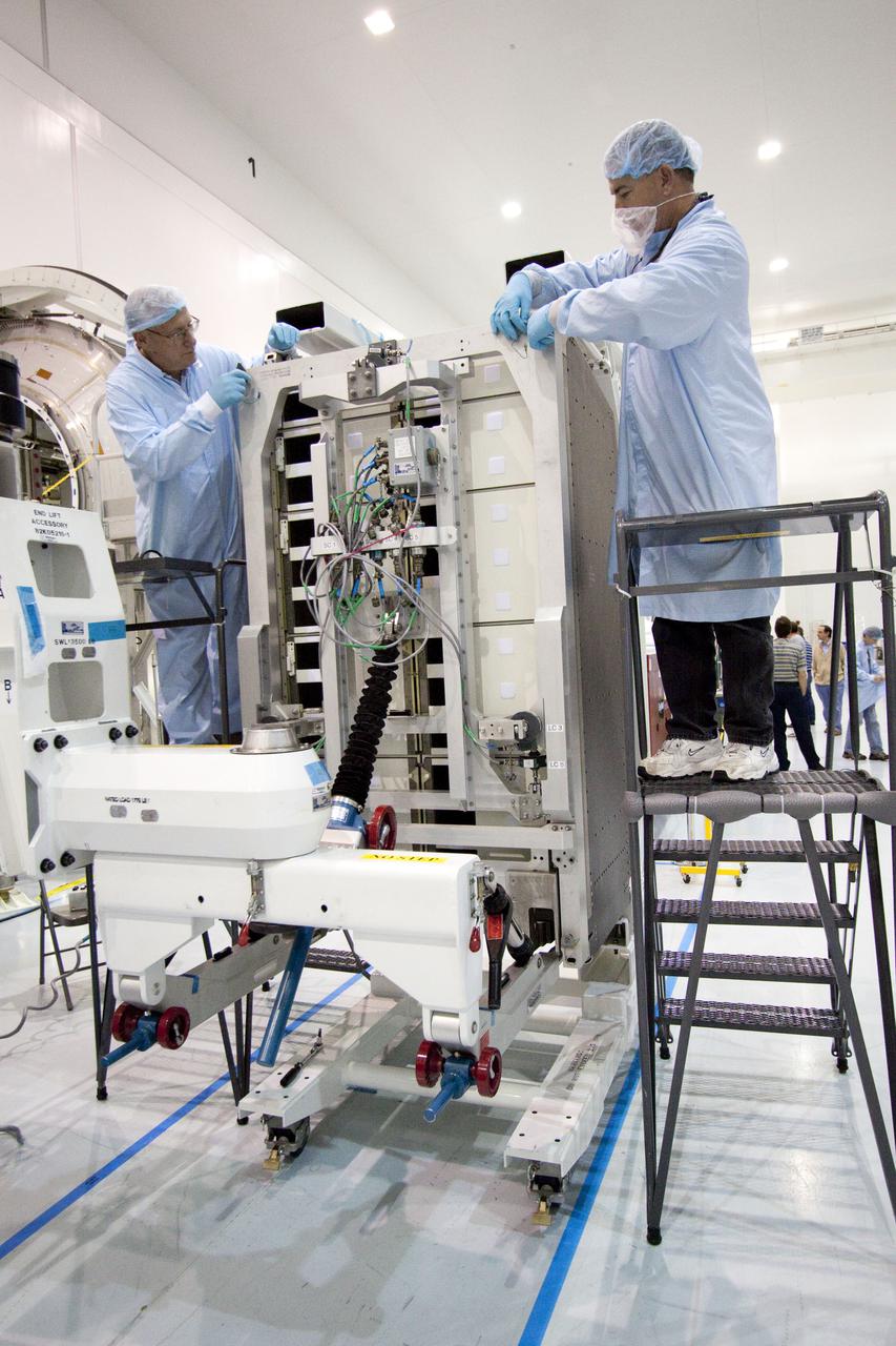 CAPE CANAVERAL, Fla. – In the Space Station Processing Facility at NASA's Kennedy Space Center in Florida, technicians prepare to install a resupply rack into the Permanent Multipurpose Module, or PMM.      The Leonardo multi-purpose logistics module, or MPLM, is being modified to become the PMM that will carry supplies and critical spare parts to the International Space Station aboard space shuttle Discovery’s STS-133 mission. Discovery, targeted to launch Nov. 1, will leave the module behind so it can be used for microgravity experiments in fluid physics, materials science, biology and biotechnology. Photo credit: NASA_Jack Pfaller