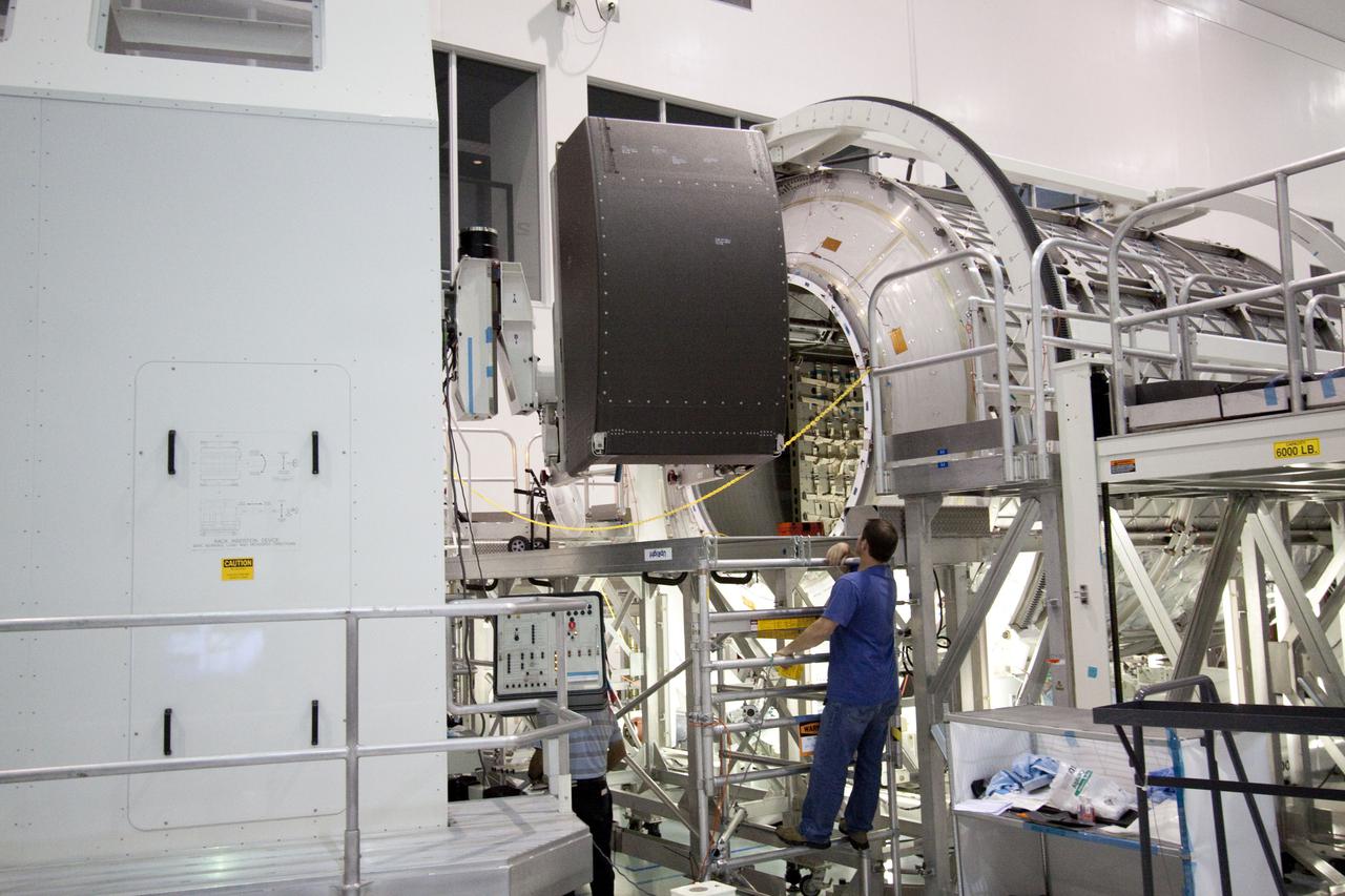 CAPE CANAVERAL, Fla. – In the Space Station Processing Facility at NASA's Kennedy Space Center in Florida, technicians begin to install a resupply rack into the Permanent Multipurpose Module, or PMM.      The Leonardo multi-purpose logistics module, or MPLM, is being modified to become the PMM that will carry supplies and critical spare parts to the International Space Station aboard space shuttle Discovery’s STS-133 mission. Discovery, targeted to launch Nov. 1, will leave the module behind so it can be used for microgravity experiments in fluid physics, materials science, biology and biotechnology. Photo credit: NASA_Jack Pfaller