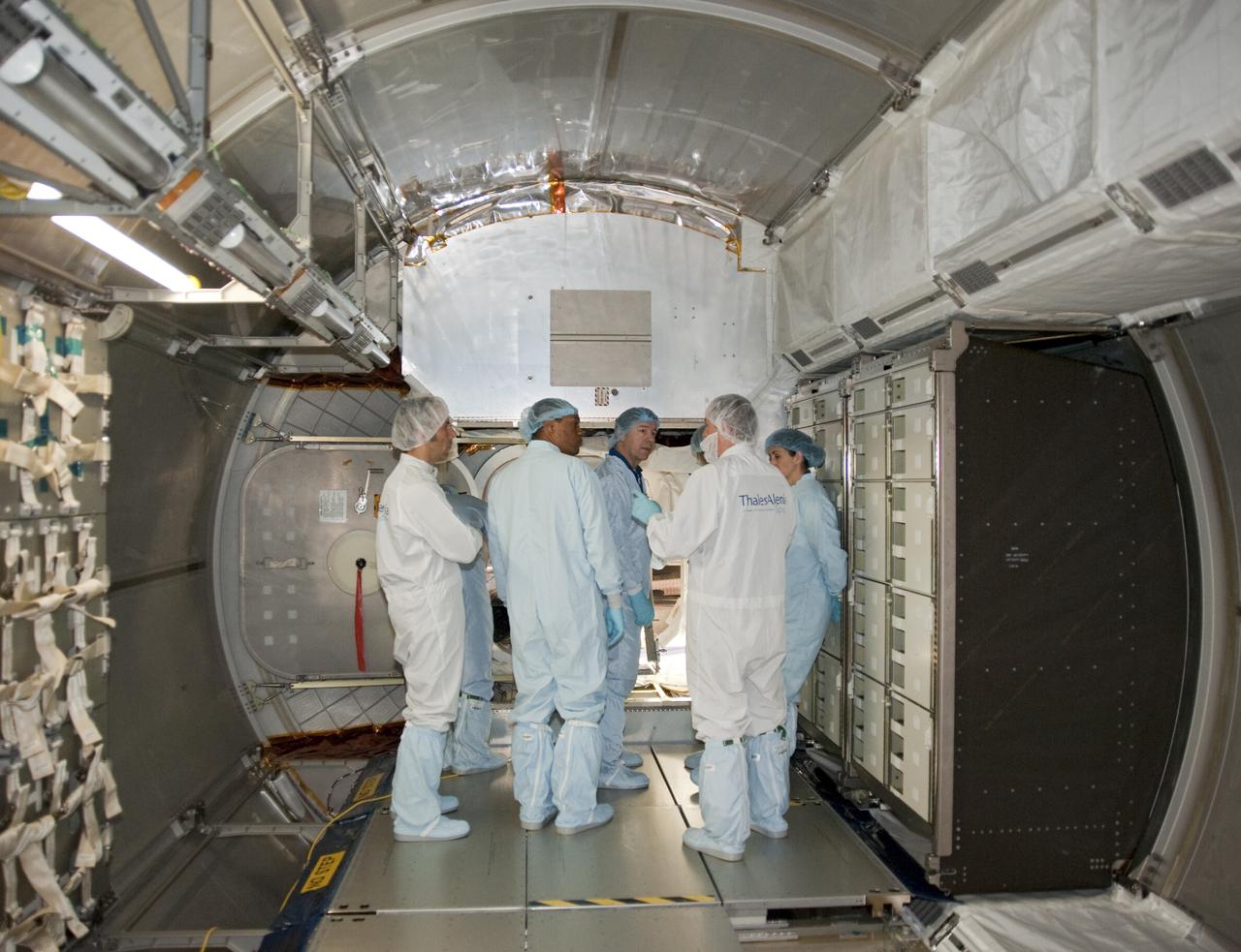 CAPE CANAVERAL, Fla. -- In the Space Station Processing Facility at NASA's Kennedy Space Center in Florida, the STS-133 crew members gather inside the Permanent Multipurpose Module, or PMM for a close look at the storage racks. The PMM will be used to carry supplies and critical spare parts to the station and will be left behind so it can be used for microgravity experiments in fluid physics, materials science, biology and biotechnology.      The astronauts are at Kennedy for the Crew Equipment Interface Test, or CEIT, which provides the crew with hands-on training and observation of shuttle and flight hardware for their mission to the International Space Station. Launch of the STS-133 mission on space shuttle Discovery is targeted for Nov. 1 at 4:33 p.m. EDT. Photo credit: NASA_Kim Shiflett
