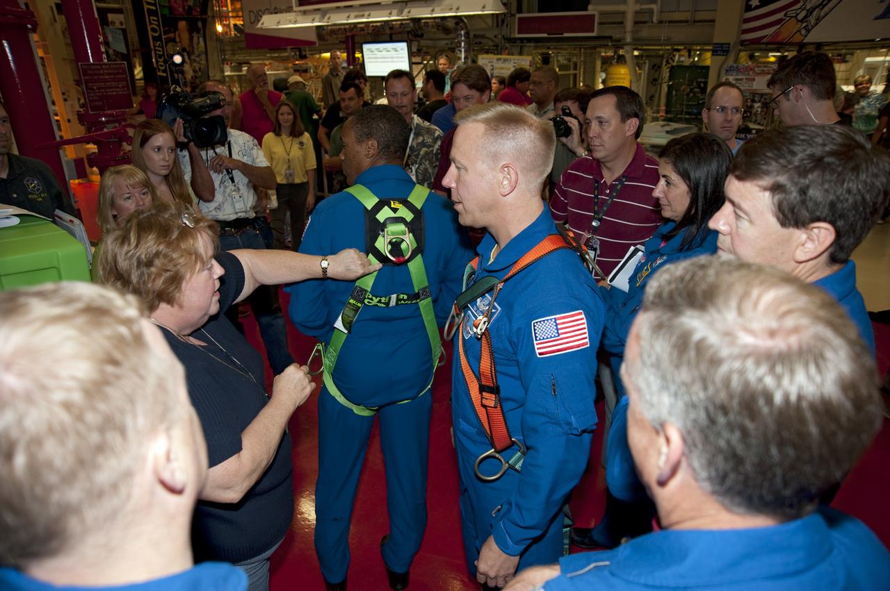 CAPE CANAVERAL, Fla. -- In Orbiter Processing Facility-3 at NASA's Kennedy Space Center in Florida, STS-133 crew members participate in training activities. Here, Mission Specialist Alvin Drew demonstrates the proper fit of a harness while Mission Specialists Tim Kopra (right), Nicole Stott, Michael Barratt; Commander Steve Lindsey (right foreground) and Pilot Eric Boe look on.      The astronauts are at Kennedy for the Crew Equipment Interface Test, or CEIT, which provides the crew with hands-on training and observation of shuttle and flight hardware for their mission to the International Space Station. Launch of the STS-133 mission on space shuttle Discovery is targeted for Nov. 1 at 4:33 p.m. EDT. Photo credit: NASA_Kim Shiflett