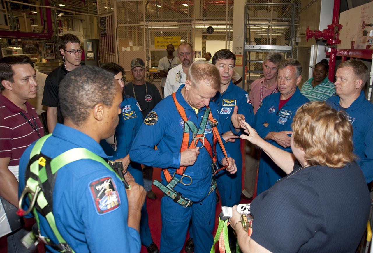 CAPE CANAVERAL, Fla. -- In Orbiter Processing Facility-3 at NASA's Kennedy Space Center in Florida, the STS-133 crew members are instructed on the correct fit of a harness. From right are Pilot Eric Boe, Commander Steve Lindsey, Mission Specialists Michael Barratt, Tim Kopra (with harness) Nicole Stott and Alvin Drew.     The astronauts are at Kennedy for the Crew Equipment Interface Test, or CEIT, which provides the crew with hands-on training and observation of shuttle and flight hardware for their mission to the International Space Station. Launch of the STS-133 mission on space shuttle Discovery is targeted for Nov. 1 at 4:33 p.m. EDT. Photo credit: NASA_Kim Shiflett