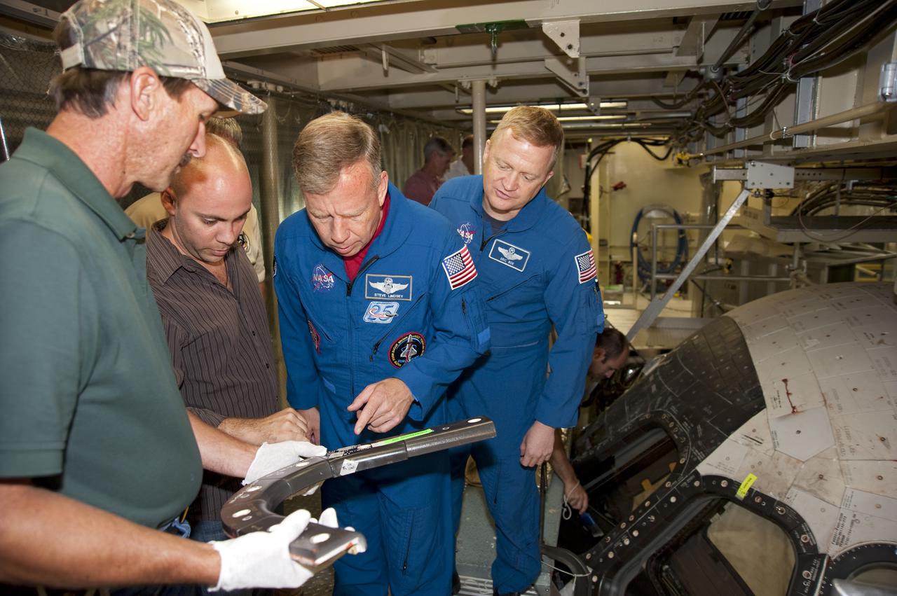 CAPE CANAVERAL, Fla. -- In Orbiter Processing Facility-3 at NASA's Kennedy Space Center in Florida, STS-133 Commander Steve Lindsey (left) and Pilot Eric Boe examine a piece of hardware that will fly on their mission.     The astronauts are at Kennedy for the Crew Equipment Interface Test, or CEIT, which provides the crew with hands-on training and observation of shuttle and flight hardware for their mission to the International Space Station. Launch of the STS-133 mission on space shuttle Discovery is targeted for Nov. 1 at 4:33 p.m. EDT. Photo credit: NASA_Kim Shiflett