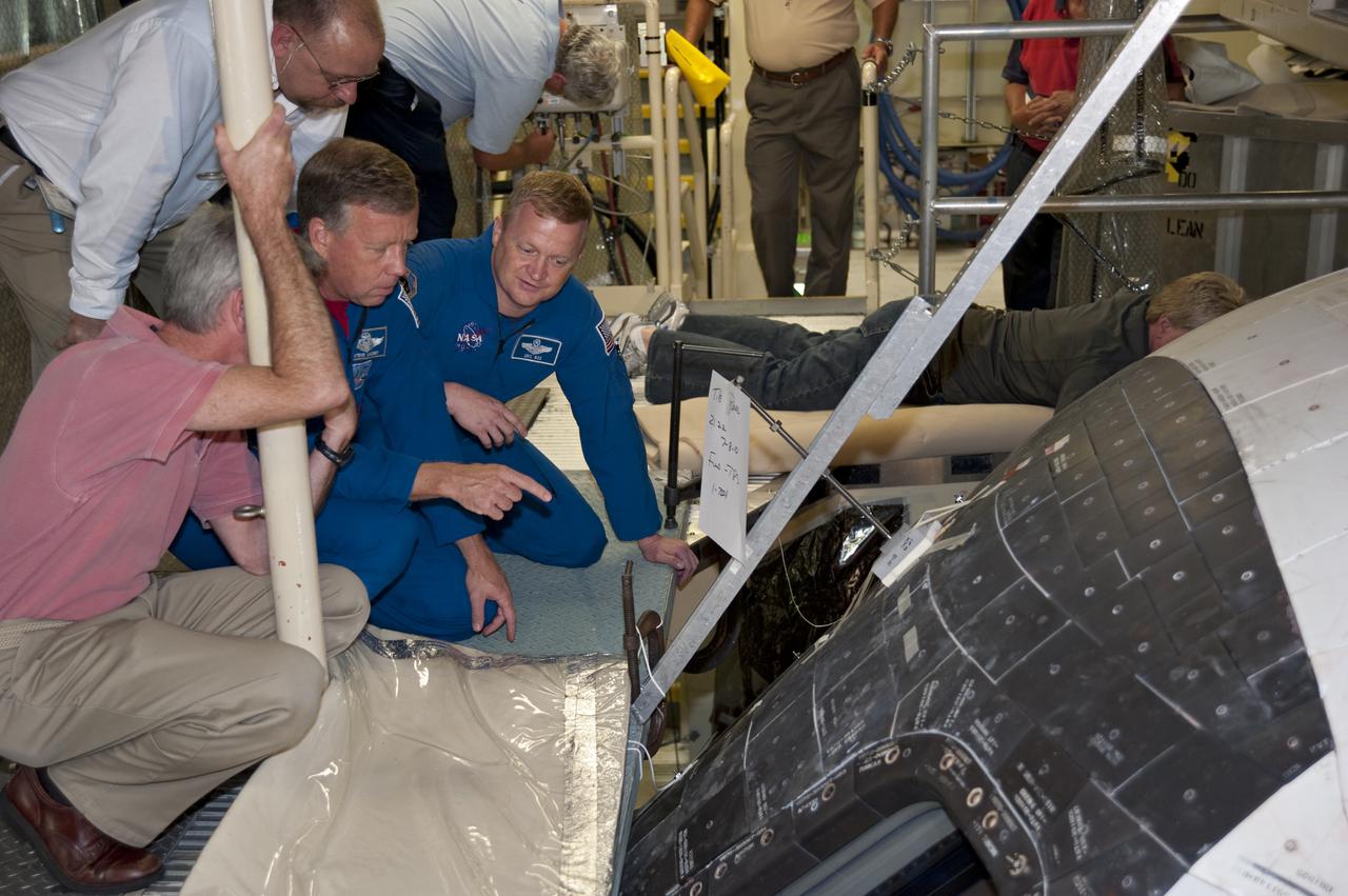CAPE CANAVERAL, Fla. -- In Orbiter Processing Facility-3 at NASA's Kennedy Space Center in Florida, STS-133 Commander Steve Lindsey and Pilot Eric Boe get a 'birds-eye' view through the window into the shuttle's cockpit.     The astronauts are at Kennedy for the Crew Equipment Interface Test, or CEIT, which provides the crew with hands-on training and observation of shuttle and flight hardware for their mission to the International Space Station. Launch of the STS-133 mission on space shuttle Discovery is targeted for Nov. 1 at 4:33 p.m. EDT. Photo credit: NASA_Kim Shiflett