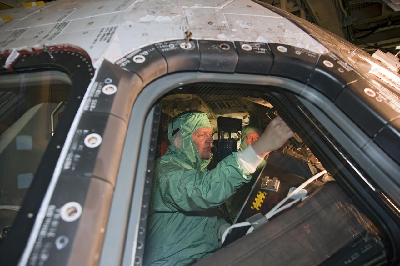 CAPE CANAVERAL, Fla. -- In Orbiter Processing Facility-3 at NASA's Kennedy Space Center in Florida, STS-133 Pilot Eric Boe and Commander Steve Lindsey (partially obscured) become familiar with the layout of the shuttle's cockpit.    The astronauts are at Kennedy for the Crew Equipment Interface Test, or CEIT, which provides the crew with hands-on training and observation of shuttle and flight hardware for their mission to the International Space Station. Launch of the STS-133 mission on space shuttle Discovery is targeted for Nov. 1 at 4:33 p.m. EDT. Photo credit: NASA_Kim Shiflett