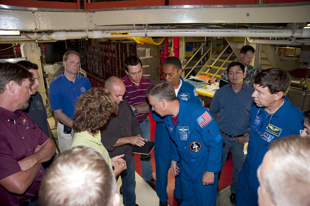 CAPE CANAVERAL, Fla. -- In Orbiter Processing Facility-3 at NASA's Kennedy Space Center in Florida, STS-133 Commander Steve Lindsey listens intently as a technician describes the features of a heat-shield tile while Mission Specialists Michael Barratt, Alvin Drew and other technicians look on.    The astronauts are at Kennedy for the Crew Equipment Interface Test, or CEIT, which provides the crew with hands-on training and observation of shuttle and flight hardware for their mission to the International Space Station. Launch of the STS-133 mission on space shuttle Discovery is targeted for Nov. 1 at 4:33 p.m. EDT. Photo credit: NASA_Kim Shiflett