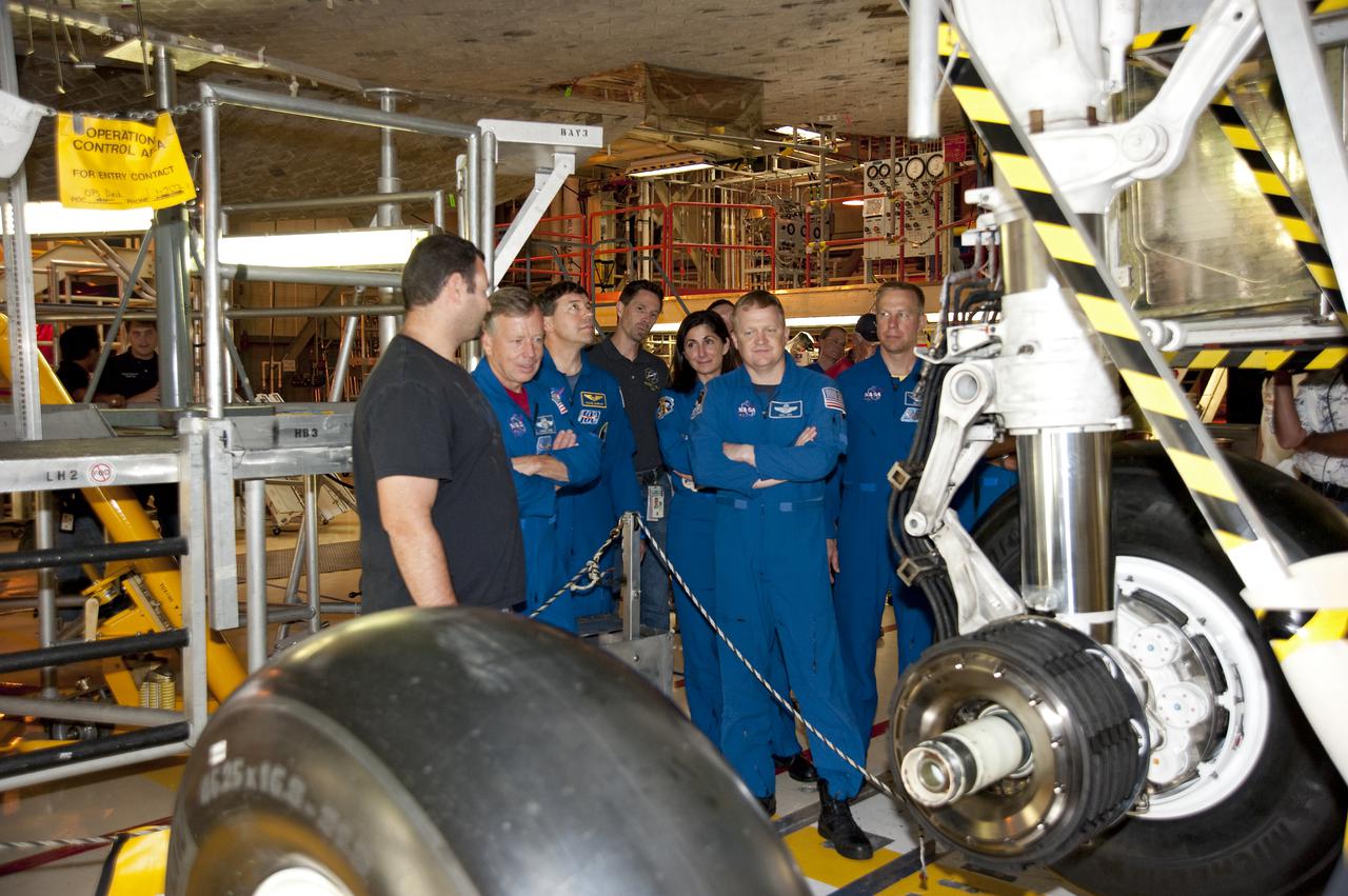 CAPE CANAVERAL, Fla. -- In Orbiter Processing Facility-3 at NASA's Kennedy Space Center in Florida, a technician discusses the shuttle's braking system to the STS-133 crew members. Pictured are Commander Steve Lindsey (left), Mission Specialist Michael Barratt, Nicole Stott; Pilot Eric Boe and Mission Specialist Tim Kopra.    The astronauts are at Kennedy for the Crew Equipment Interface Test, or CEIT, which provides the crew with hands-on training and observation of shuttle and flight hardware for their mission to the International Space Station. Launch of the STS-133 mission on space shuttle Discovery is targeted for Nov. 1 at 4:33 p.m. EDT. Photo credit: NASA_Kim Shiflett