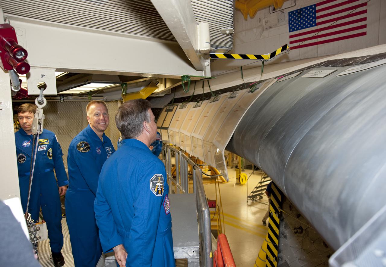 CAPE CANAVERAL, Fla. -- In Orbiter Processing Facility-3 at NASA's Kennedy Space Center in Florida, STS-133 Commander examines the shuttle's wing leading edge while Mission Specialist Tim Kopra and Michael Barratt look on.    The astronauts are at Kennedy for the Crew Equipment Interface Test, or CEIT, which provides the crew with hands-on training and observation of shuttle and flight hardware for their mission to the International Space Station. Launch of the STS-133 mission on space shuttle Discovery is targeted for Nov. 1 at 4:33 p.m. EDT. Photo credit: NASA_Kim Shiflett