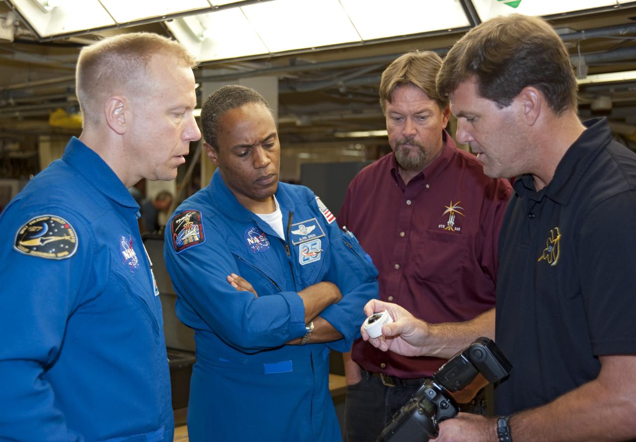 CAPE CANAVERAL, Fla. -- In Orbiter Processing Facility-3 at NASA's Kennedy Space Center in Florida, STS-133 Mission Specialists Tim Kopra (left) and Alvin Drew listen intently as a technician describes a piece of equipment they'll use while in space.    The astronauts are at Kennedy for the Crew Equipment Interface Test, or CEIT, which provides the crew with hands-on training and observation of shuttle and flight hardware for their mission to the International Space Station. Launch of the STS-133 mission on space shuttle Discovery is targeted for Nov. 1 at 4:33 p.m. EDT. Photo credit: NASA_Kim Shiflett