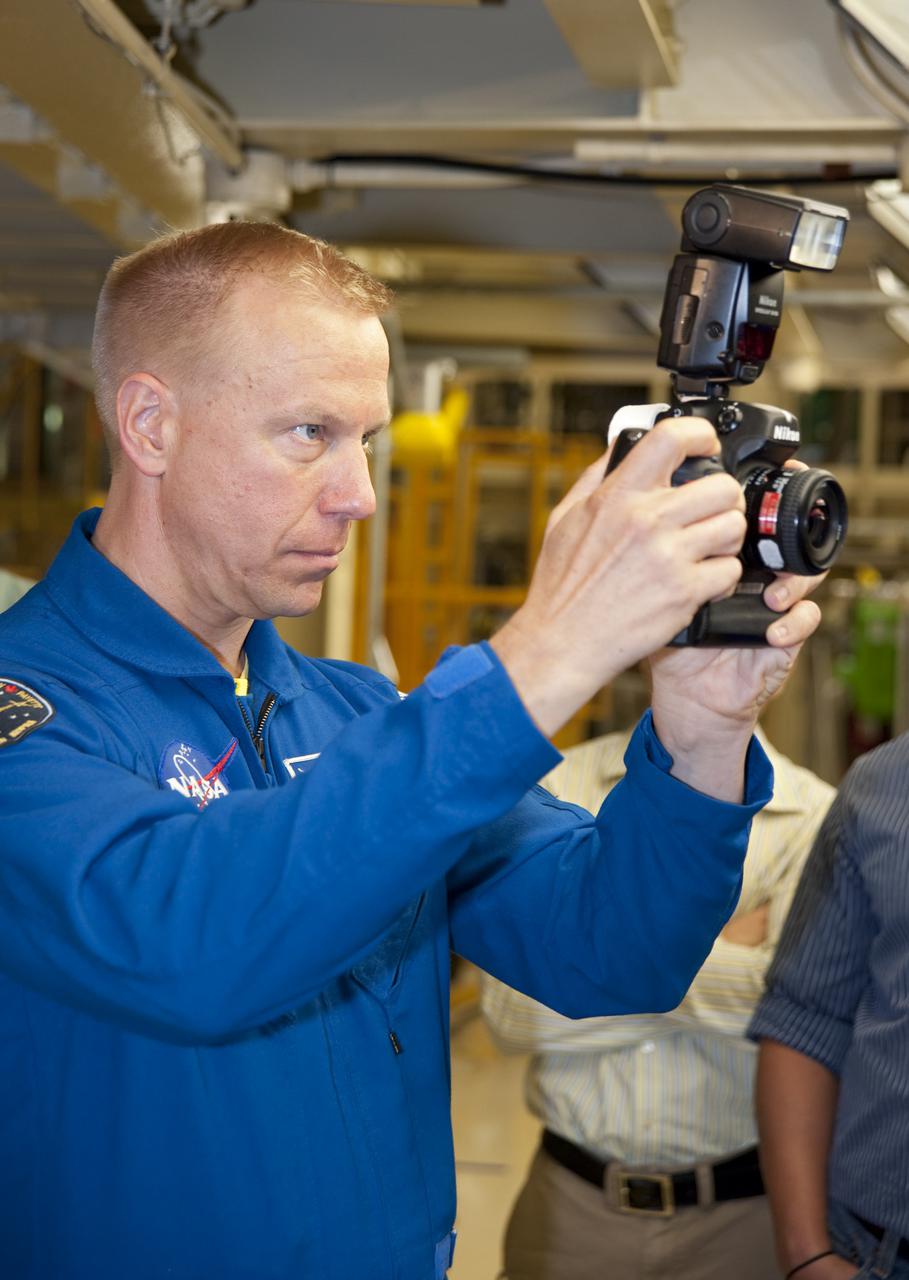 CAPE CANAVERAL, Fla. -- In Orbiter Processing Facility-3 at NASA's Kennedy Space Center in Florida, STS-133 Mission Specialist Tim Kopra looks through the viewfinder of a camera that he will  use while in space.    The astronauts are at Kennedy for the Crew Equipment Interface Test, or CEIT, which provides the crew with hands-on training and observation of shuttle and flight hardware for their mission to the International Space Station. Launch of the STS-133 mission on space shuttle Discovery is targeted for Nov. 1 at 4:33 p.m. EDT. Photo credit: NASA_Kim Shiflett