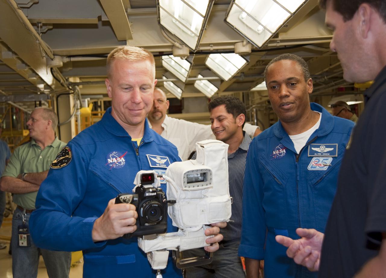 CAPE CANAVERAL, Fla. -- In Orbiter Processing Facility-3 at NASA's Kennedy Space Center in Florida, STS-133 Mission Specialist Tim Kopra holds a camera that he will use while in space. Mission Specialist Alvin Drew looks on.    The astronauts are at Kennedy for the Crew Equipment Interface Test, or CEIT, which provides the crew with hands-on training and observation of shuttle and flight hardware for their mission to the International Space Station. Launch of the STS-133 mission on space shuttle Discovery is targeted for Nov. 1 at 4:33 p.m. EDT. Photo credit: NASA_Kim Shiflett