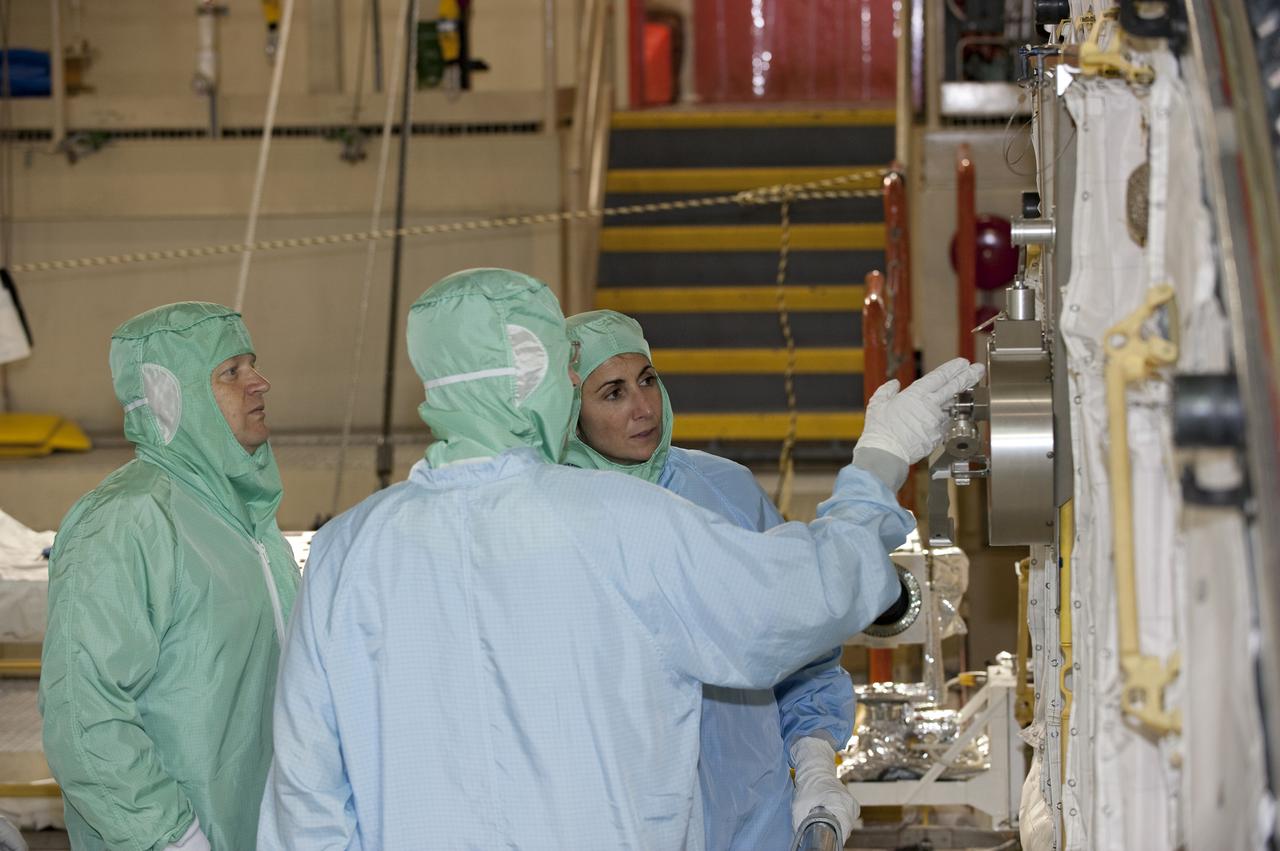 CAPE CANAVERAL, Fla. -- In Orbiter Processing Facility-3 at NASA's Kennedy Space Center in Florida, STS-133 Pilot Eric Boe (left) and Mission Specialist Nicole Stott listen to a technician as he describes an element of the shuttle's payload bay.    The astronauts are at Kennedy for the Crew Equipment Interface Test, or CEIT, which provides the crew with hands-on training and observation of shuttle and flight hardware for their mission to the International Space Station. Launch of the STS-133 mission on space shuttle Discovery is targeted for Nov. 1 at 4:33 p.m. EDT. Photo credit: NASA_Kim Shiflett
