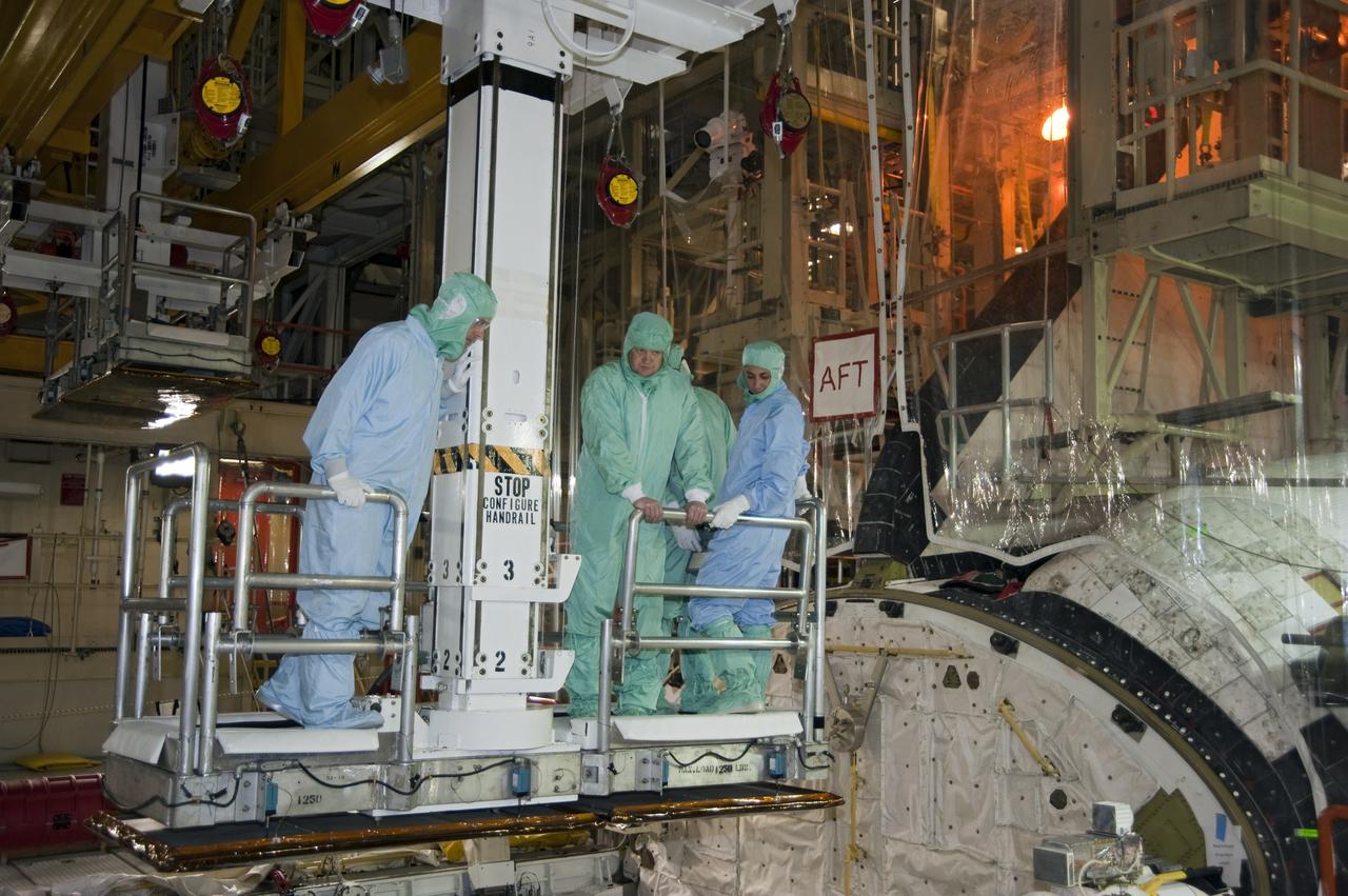 CAPE CANAVERAL, Fla. -- Attired in clean-room gear, known as 'bunny suits,' STS-133 Pilot Eric Boe and Mission Specialist Nicole Stott peer into the shuttle's payload bay under the watchful eye of a technician in Orbiter Processing Facility-3 at NASA's Kennedy Space Center in Florida.    The astronauts are at Kennedy for the Crew Equipment Interface Test, or CEIT, which provides the crew with hands-on training and observation of shuttle and flight hardware for their mission to the International Space Station. Launch of the STS-133 mission on space shuttle Discovery is targeted for Nov. 1 at 4:33 p.m. EDT. Photo credit: NASA_Kim Shiflett