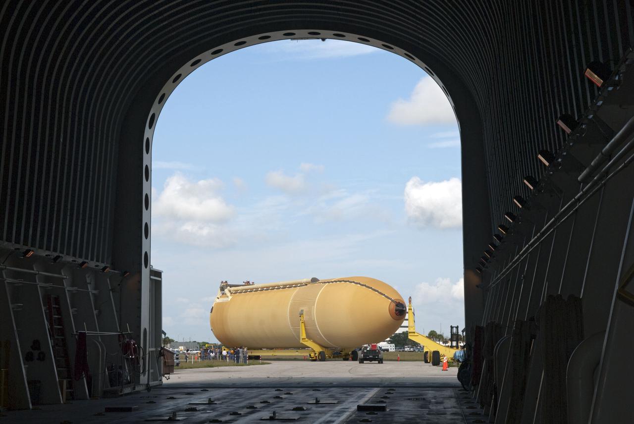 CAPE CANAVERAL, Fla. -- Viewed from inside the Pegasus barge docked in the turn basin at NASA's Kennedy Space Center in Florida, workers accompany the newly offloaded External Tank-138. The external fuel tank arrived in Florida on July 13, from NASA's Michoud Assembly Facility near New Orleans. ET-138, the last newly manufactured tank, was originally designated to fly on Endeavour's STS-134 mission to the International Space Station, but later reassigned to fly on space shuttle Atlantis' final mission, STS-135. For information, visit www.nasa.gov_shuttle. Photo credit: NASA_Jim Grossmann