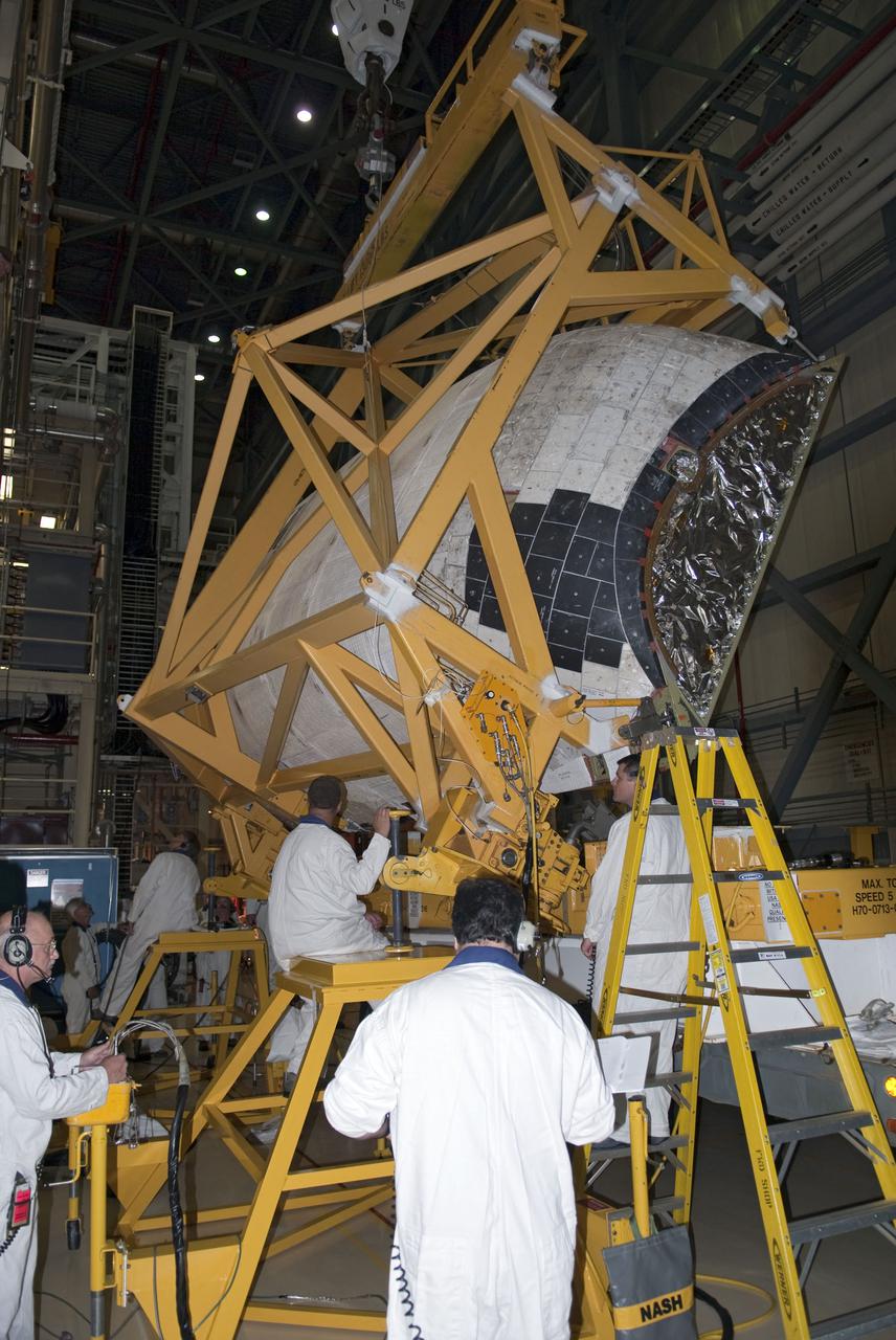 CAPE CANAVERAL, Fla. -- In Orbiter Processing Facility-3 at NASA's Kennedy Space Center in Florida, technicians assisted by an overhead crane prepare to install the right-hand orbital maneuvering system, or OMS, pod on space shuttle Discovery.       Discovery and its crew will deliver the Permanent Multipurpose Module, or PMM, which will carry supplies and critical spare parts on the STS-133 mission to the International Space Station. The module will be left behind so it can be used for microgravity experiments in fluid physics, materials science, biology and biotechnology. For more information go to www.nasa.gov_shuttle.  Photo credit: NASA_Ben Smegelsky