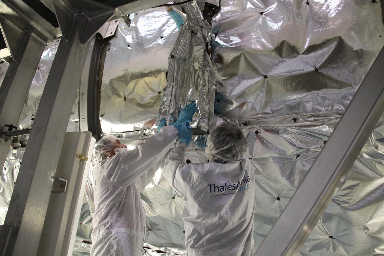 CAPE CANAVERAL, Fla. – In the Space Station Processing Facility at NASA's Kennedy Space Center in Florida, technicians install multi-layer insulation on the Meteoroids and Debris Protective Shield of the Permanent Multipurpose Module, or PMM. The reflective silver mesh is Mylar, which is aluminized to protect hardware aboard the International Space Station from solar thermal radiation.  The Leonardo multi-purpose logistics module, or MPLM, is being modified to become the PMM that will carry supplies and critical spare parts to the station aboard space shuttle Discovery’s STS-133 mission. Discovery, targeted to launch Nov. 1, will leave the module behind so it can be used for microgravity experiments in fluid physics, materials science, biology and biotechnology. Photo credit: NASA_Troy Cryder
