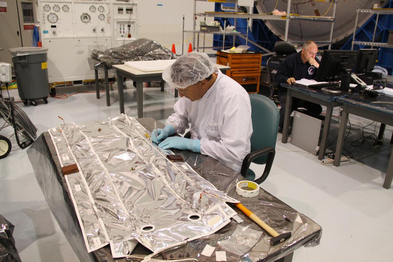 CAPE CANAVERAL, Fla. – In the Space Station Processing Facility at NASA's Kennedy Space Center in Florida, a technician inspects multi-layer insulation before it is installed on the Meteoroids and Debris Protective Shield of the Permanent Multipurpose Module, or PMM. The reflective silver mesh is Mylar, which is aluminized to protect hardware aboard the International Space Station from solar thermal radiation.  The Leonardo multi-purpose logistics module, or MPLM, is being modified to become the PMM that will carry supplies and critical spare parts to the station aboard space shuttle Discovery’s STS-133 mission. Discovery, targeted to launch Nov. 1, will leave the module behind so it can be used for microgravity experiments in fluid physics, materials science, biology and biotechnology. Photo credit: NASA_Troy Cryder