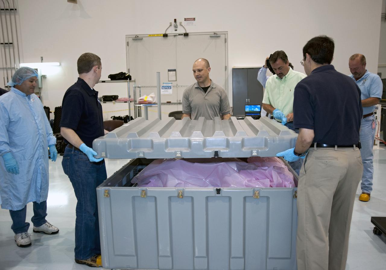 CAPE CANAVERAL, Fla. -- In the Space Station Processing Facility at NASA's Kennedy Space Center in Florida, workers lift the lid off of a crate containing Robonaut R2, a dexterous humanoid astronaut helper.      Robonaut R2 will fly to the International Space Station aboard space shuttle Discovery on the STS-133 mission. Although it will initially only participate in operational tests, upgrades could eventually allow the robot to realize its true purpose -- helping spacewalking astronauts with tasks outside the space station. Photo credit: NASA_Kim Shiflett