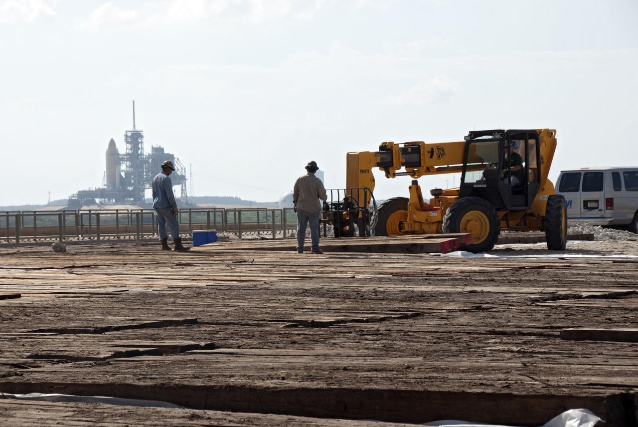PAD 39B DEMO OPS - PLANKS BEING LAID ON PAD SURFACE FOR DEMOLITION