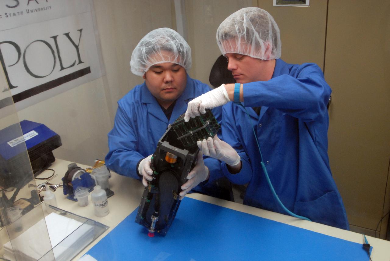 San Luis Obispo, CA - Roland Coelho and Ryan Nugent, students at California Polytechnic State University, integrate mini research satellites or CubeSats into a Poly Picosatellite Orbital Deployer, or PPOD, container. The PPOD and CubeSat Project were developed by California Polytechnic State University in San Luis Obispo, Calif., and Stanford University’s Space Systems Development Lab for use on NASA’s Educational Launch of Nanosatellite, or ELaNa missions. Each CubeSat measures about four inches cubed; about the same volume as a quart. The CubeSats weigh about 2.2 pounds, must conform to standard aerospace materials and must operate without propulsion.  U.S. Air Force Photo/Mr. Jerry E. Clemens, Jr.