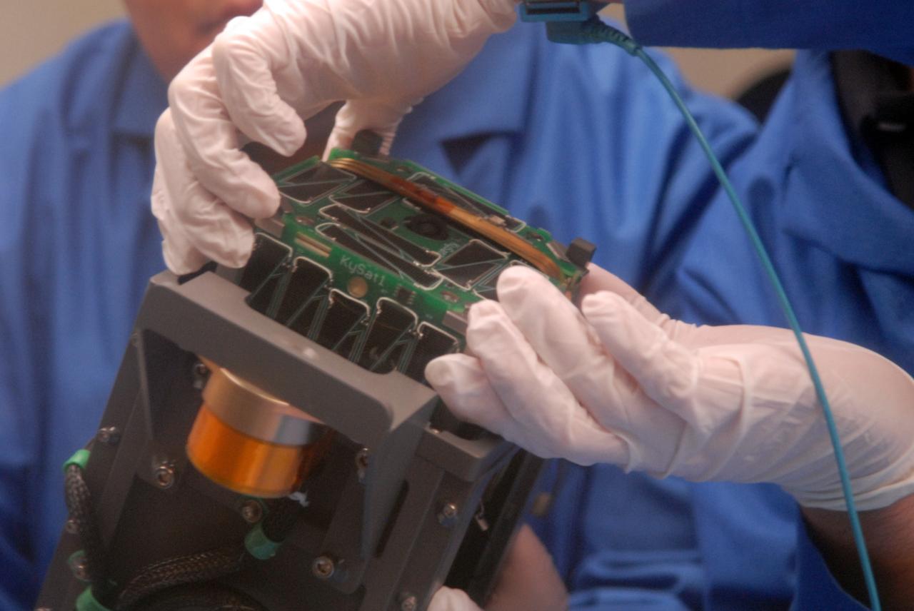 San Luis Obispo, CA - Roland Coelho and Ryan Nugent, students at California Polytechnic State University, integrate mini research satellites or CubeSats into a Poly Picosatellite Orbital Deployer, or PPOD, container. The PPOD and CubeSat Project were developed by California Polytechnic State University in San Luis Obispo, Calif., and Stanford University’s Space Systems Development Lab for use on NASA’s Educational Launch of Nanosatellite, or ELaNa missions. Each CubeSat measures about four inches cubed; about the same volume as a quart. The CubeSats weigh about 2.2 pounds, must conform to standard aerospace materials and must operate without propulsion.  U.S. Air Force Photo/Mr. Jerry E. Clemens, Jr.
