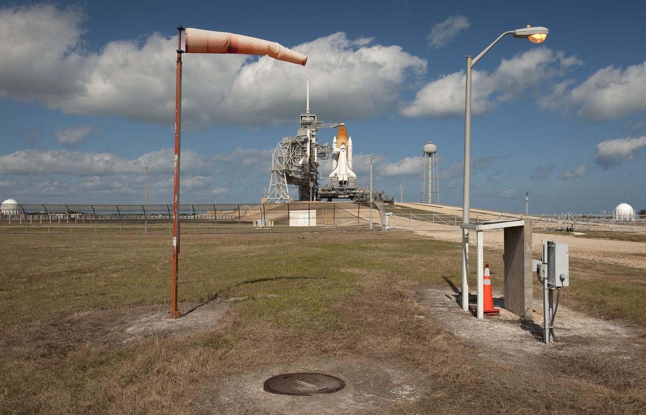 The space shuttle Endeavour is seen as strong winds inflate a windsock, Saturday Feb. 6, 2010 at pad 39a of the NASA Kennedy Space Center in Cape Canaveral, Florida.  Endeavour  and the crew members of the STS-130 mission are set to launch on Sunday at 4:39 a.m. EST.  Photo Credit: (NASA/Bill Ingalls)