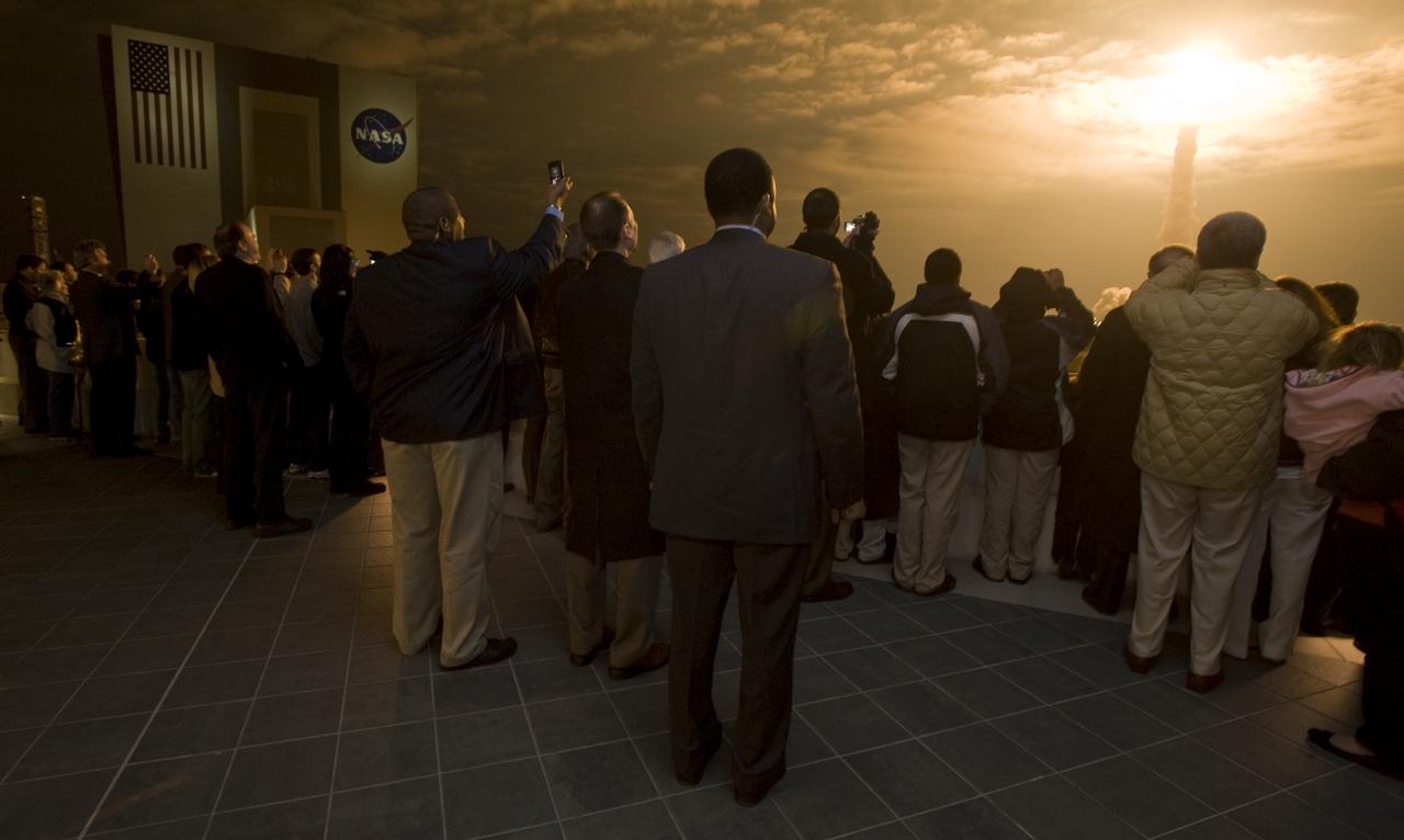 Guests look on from the terrace of Operations Support Building II as space shuttle Endeavour launches from pad 39A on the STS-130 mission early Monday, Feb. 8, 2010, at Kennedy Space Center in Cape Canaveral, Fla. Endeavour and its crew will deliver to the International Space Station a third connecting module, the Italian-built Tranquility node and the seven-windowed cupola, which will be used as a control room for robotics. The mission will feature three spacewalks. Photo Credit: (NASA/Paul E. Alers)