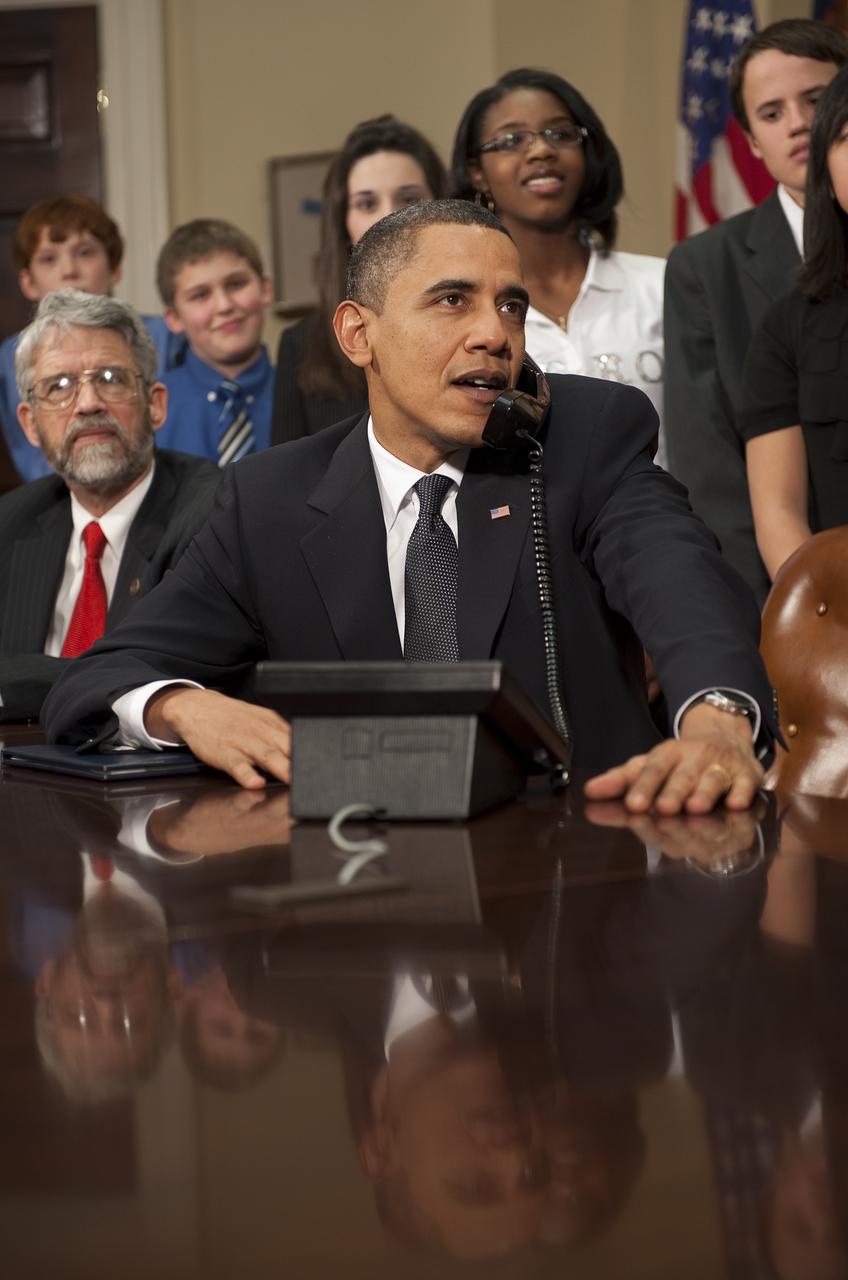 U.S. President Barack Obama, accompanied by White House Science Adviser John Holdren, left, Congressman C.A. "Dutch" Ruppersberger (D-MD) and middle school children, talks on the phone from the Roosevelt Room of the White House to astronauts on the International Space Station, Wednesday, Feb. 17, 2010 in Washington. Photo Credit: (NASA/Bill Ingalls)