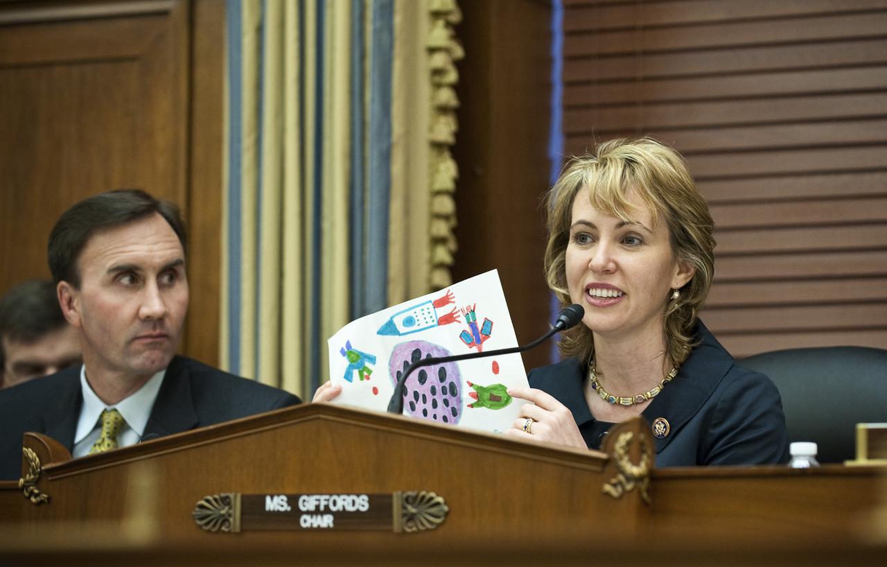 U.S. Congresswoman Gabrielle Giffords, D-AZ, left, shows a childs' drawing while U.S. Congressman Pete Olson, R-TX, looks on at the U.S. House of Representatives' Committee on Science and Technology, Subcommittee on Space and Aeronautics to discuss proposed changes to NASA's exploration program on Wednesday, March 24, 2010, on Capitol Hill in Washington. Photo Credit: (NASA/Carla Cioffi)