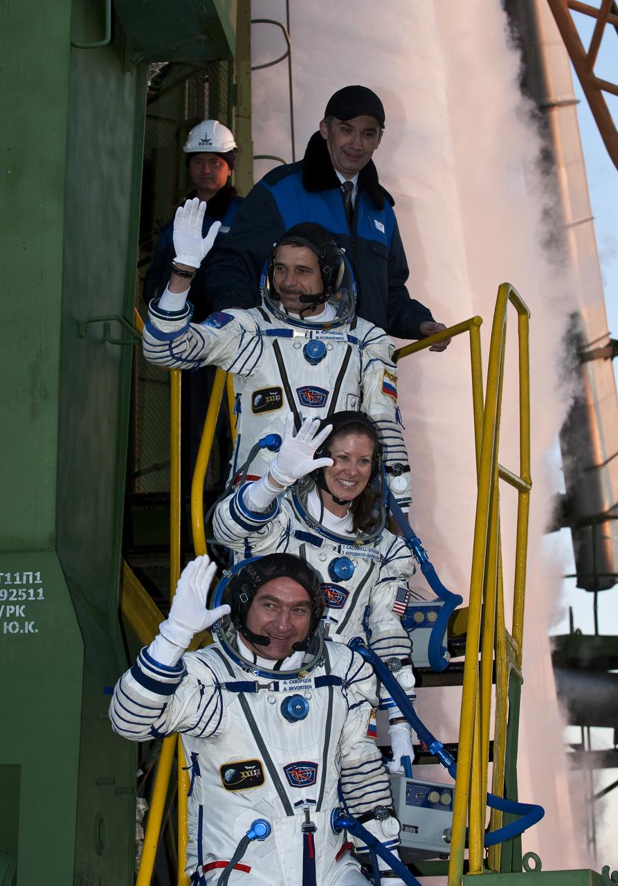 Expedition 23 Flight Engineer Mikhail Kornienko of Russia, top, NASA Flight Engineer Tracy Caldwell Dyson of the U.S. and Soyuz Commander Alexander Skvortsov of Russia, bottom, wave farewell from the bottom of the Soyuz rocket at the Baikonur Cosmodrome in Baikonur, Kazakhstan, Friday, April 2, 2010. Kornienko, Caldwell Dyson and Skvortsov launched in their Soyuz TMA-18 rocket from the Baikonur Cosmodrome in Kazakhstan on Friday, April 2, 2010 at 10:04 a.m. Photo Credit: (NASA/Carla Cioffi)