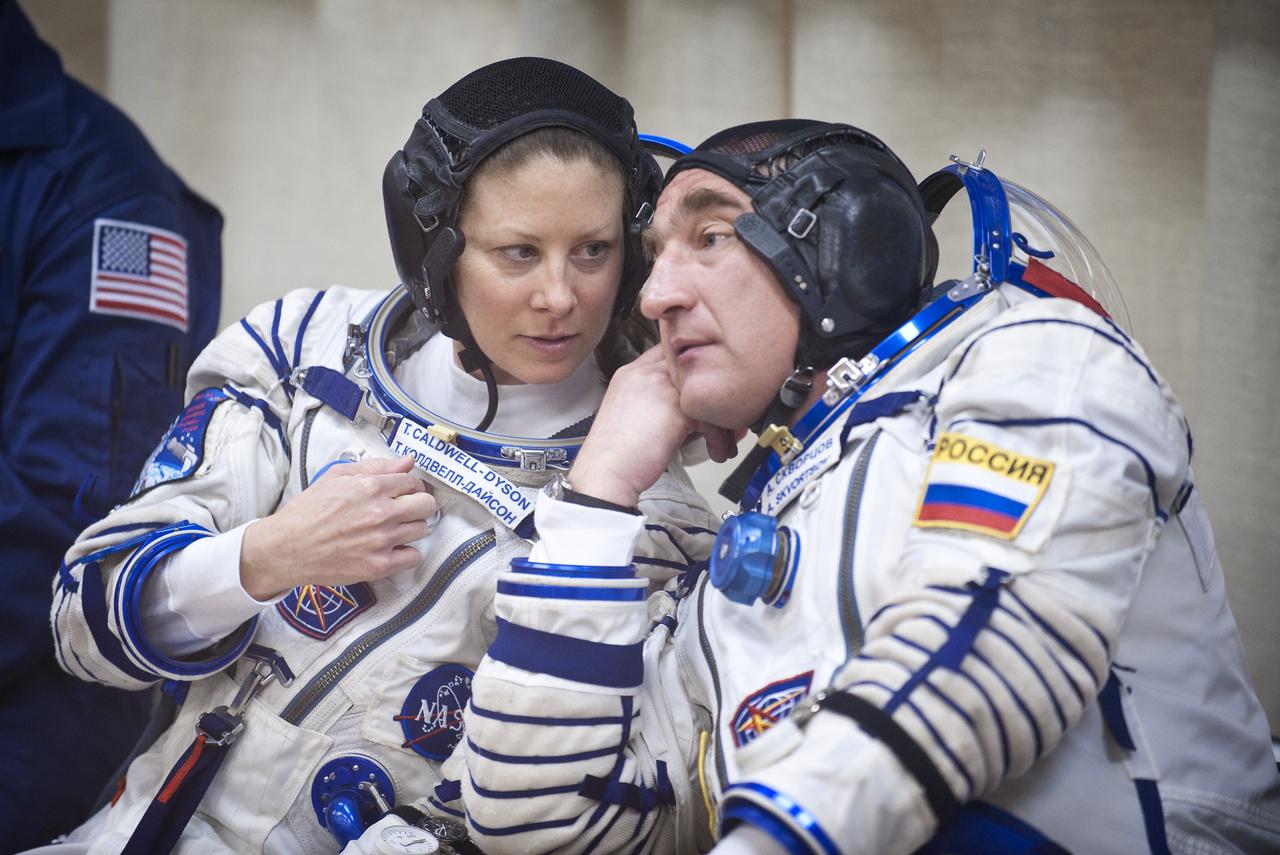 Expedition 23 NASA Flight Engineer Tracy Caldwell Dyson, left, talks with Soyuz Commander Alexander Skvortsov of Russia, while Flight Engineer Mikhail Kornienko of Russia has his Russian Sokol suit prepared for launch at the Baikonur Cosmodrome in Baikonur, Kazakhstan, Friday, April 2, 2010. The Expedition 23 crew members launched in their Soyuz TMA-18 rocket from the Baikonur Cosmodrome in Kazakhstan on Friday, April 2, 2010. (Photo Credit: NASA/Bill Ingalls)