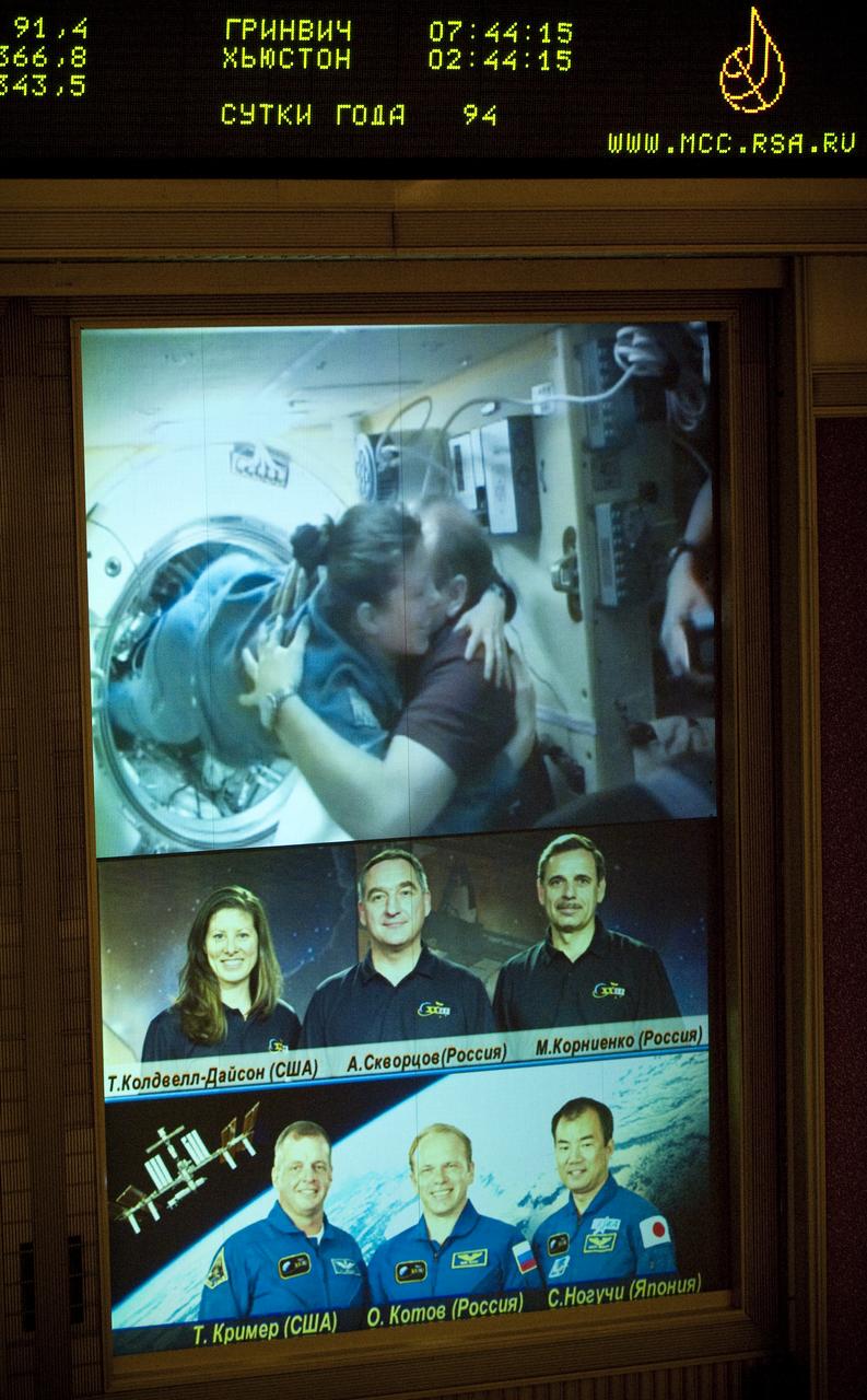 A large TV screen in Russian Mission Control Center in Korolev, Russia shows Expedition 23 Commander Oleg Kotov, right, welcoming NASA astronaut and Flight Engineer Tracy Caldwell Dyson onboard the International Space Station after she and fellow crew members Expedition 23 Soyuz Commander Alexander Skvortsov and Flight Engineer Mikhail Kornienko docked their Soyuz TMA-18 spacecraft on Sunday, April 4, 2010. Photo Credit: (NASA/Carla Cioffi)