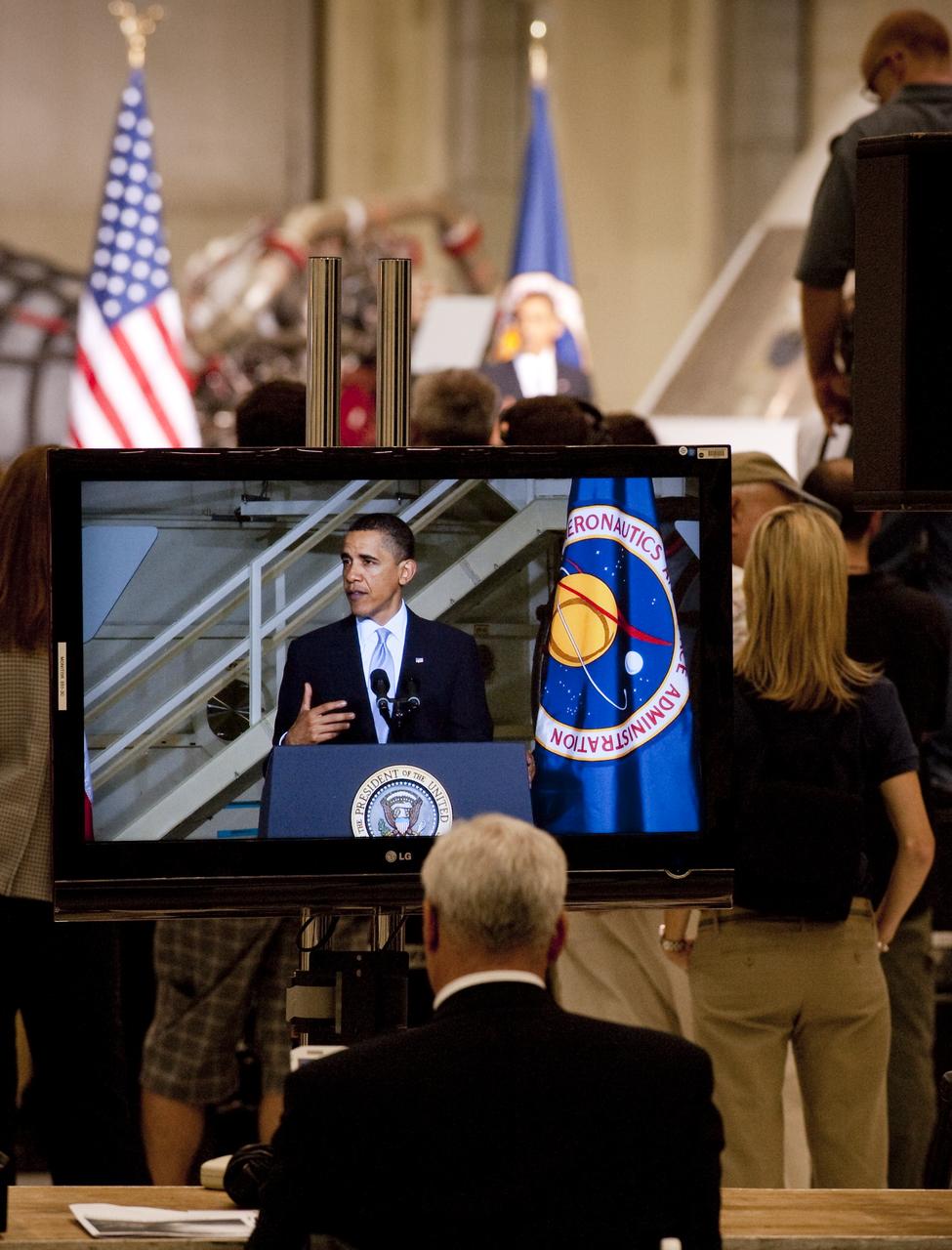 Members of the press watch on monitors as President Barack Obama delivers a speech at the Operations and Checkout Building at NASA Kennedy Space Center in Cape Canaveral, Fla. on Thursday, April 15, 2010. Obama visited Kennedy Space Center to deliver remarks on the bold new course the Administration is charting for NASA and the future of U.S. leadership in human space flight. Photo Credit: (NASA/Bill Ingalls)