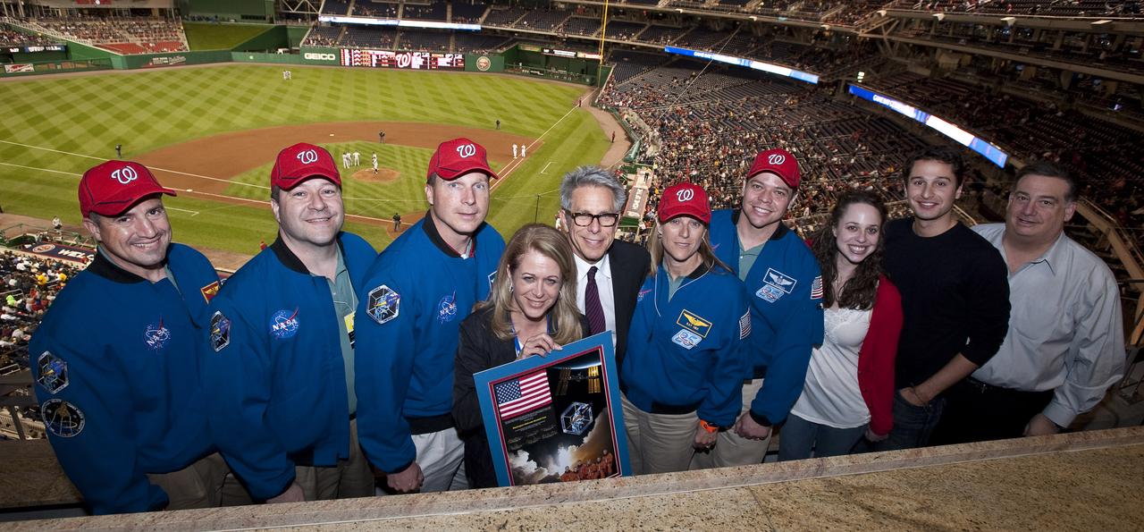 The crew of STS-130 present the principal owner of the Washington Nationals, Debra Lerner Cohen (holding montage) with a montage of their mission, Tuesday, April 20, 2010 at Nationals Park in Washington.  From left are seen Commander George Zamka, Mission Specialist Nicholas Patrick, Pilot Terry Virts, Debra Lerner Cohen, Edward Cohen, Mission Specialist Kathryn Hire, Mission Specialist Robert Behnken, Lauren Lerner, Jacob Lerner and Alan Gottlieb.  Photo Credit:  (NASA/Carla Cioffi)