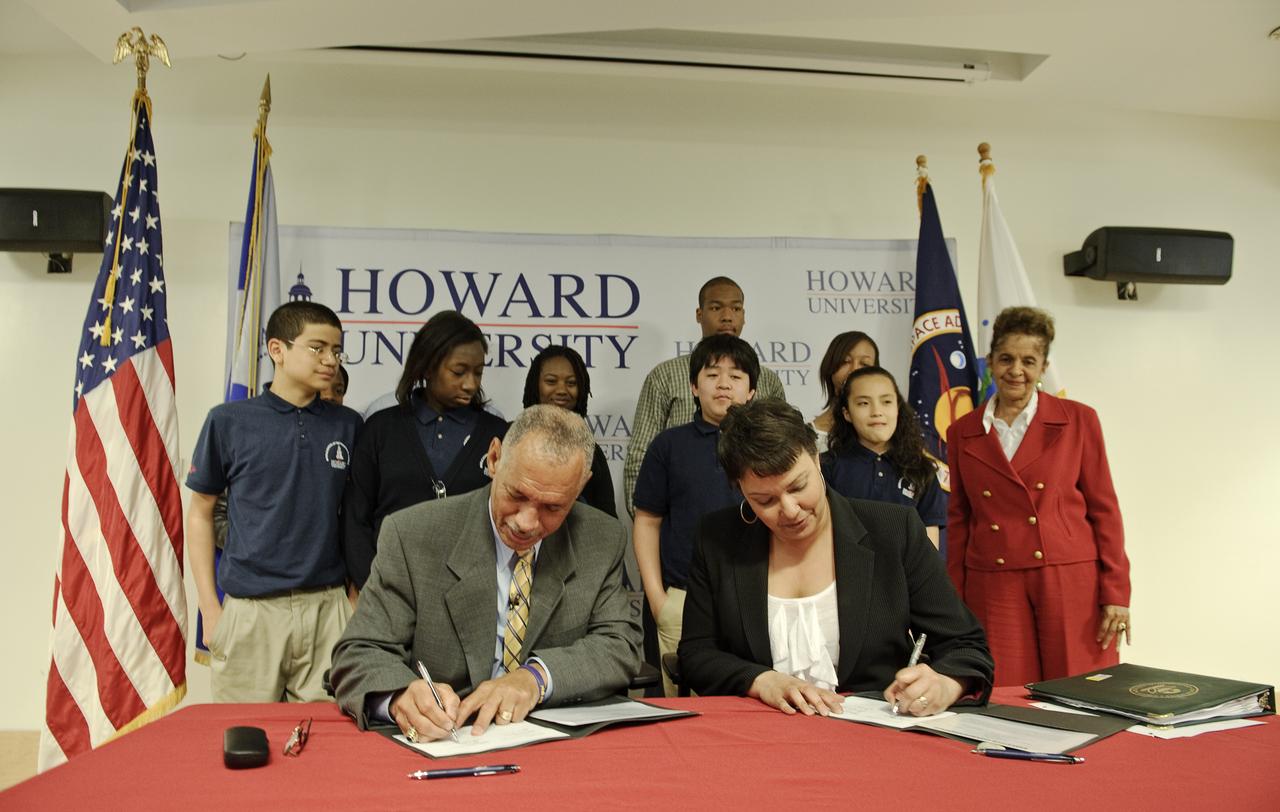 NASA Administrator Charles Bolden, left, and U.S. Environmental Protection Agency (EPA) Administrator Lisa P.  Jackson, right, sign a Memorandum of Agreement (MOA) to promote collaboration between the two agencies for cooperation in environmental and Earth sciences and environmental management applications as students from the Howard University Middle School of Mathematics and Science look on, Monday, April 26, 2010, at the school in Washington. Photo Credit: (NASA/Paul E. Alers)