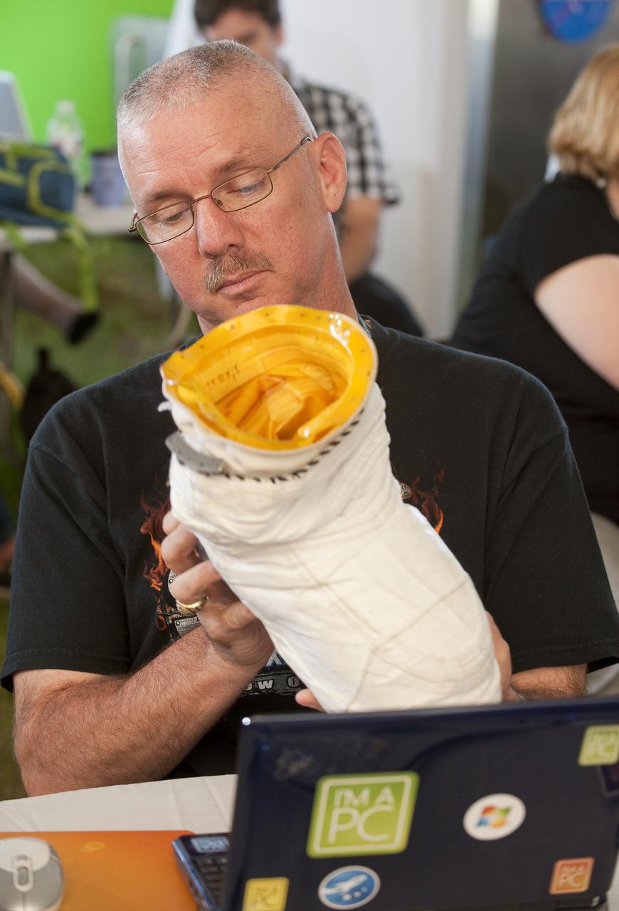 Richard Hay, @WinObs, looks at an astronaut boot, during the two-day STS-132 Launch Tweetup at Kennedy Space Center, Thursday, May 13, 2010, in Cape Canaveral, Fla.  NASA Twitter followers in attendance will have the opportunity to take a tour of NASA's Kennedy Space Center, view the space shuttle launch and speak with shuttle technicians, engineers, astronauts and managers. Photo Credit: (NASA/Paul E. Alers)