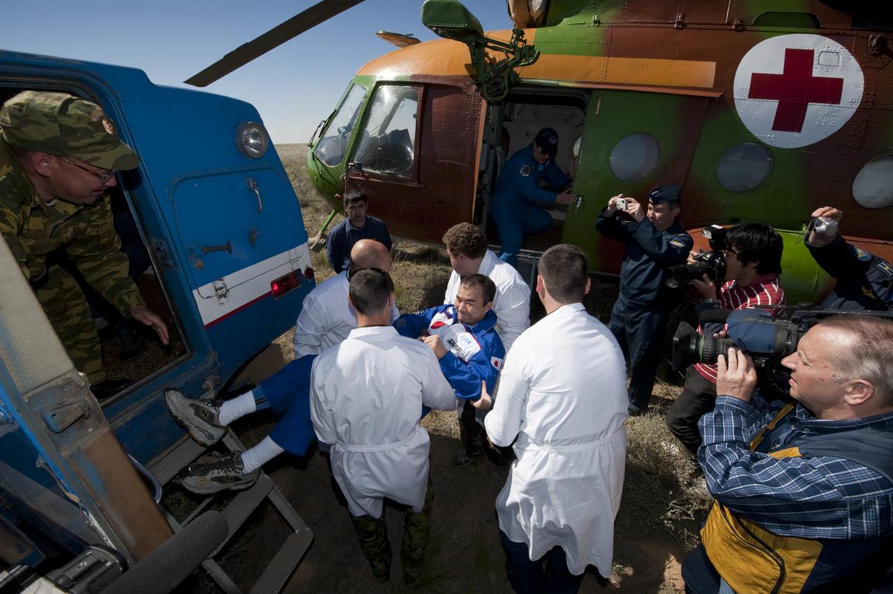 Expedition 23 Flight Engineer Soichi Noguchi is helped from a Russian Search and Recovery all terrain vehicle to his helicopter shortly after he and fellow crew members T.J. Creamer and Commander Oleg Kotov landed in their Soyuz TMA-17 capsule near the town of Zhezkazgan, Kazakhstan on Wednesday, June 2, 2010. NASA Astronaut Creamer, Russian Cosmonaut Kotov and Japanese Astronaut Noguchi are returning from six months onboard the International Space Station where they served as members of the Expedition 22 and 23 crews. Photo Credit: (NASA/Bill Ingalls)