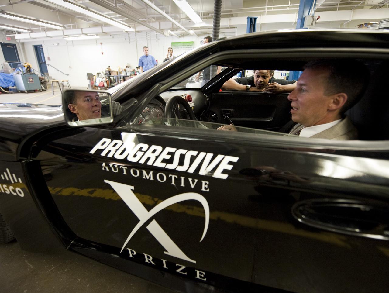 NASA Chief Technologist Bobby Braun sits in the West Philly X Prize hybrid sports car as Sowande Gay, a student member of the West Philly Hybrid Team at West Philadelphia High School, explains the modifications made to the car, in Philadelphia, Monday, June 7, 2010.  The prize-winning West Philly Hybrid X Team has drawn international recognition as the only high school among 22 finalists in the Progressive Insurance Automotive X Prize (PIAXP) competition to develop cars that achieve over 100 MPG.  Photo Credit: (NASA/Bill Ingalls)