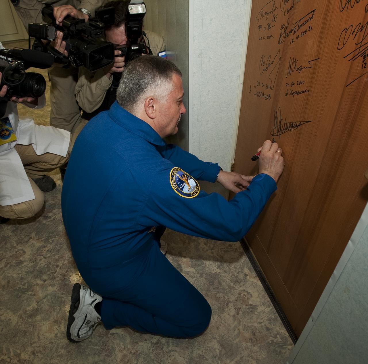 Expedition 24 Soyuz Commander and Flight Engineer Fyodor Yurchikhin performs the traditional door signing prior to his launch to the International Space Station, Tuesday, June 15, 2010 at the Cosmonaut Hotel in Baikonur, Kazakhstan. Yurchikhin was launched onboard the Soyuz rocket the following morning with Expedition 24 Flight Engineer Shannon Walker and Doug Wheelock on a mission to the ISS.  Photo Credit: (NASA/Carla Cioffi)