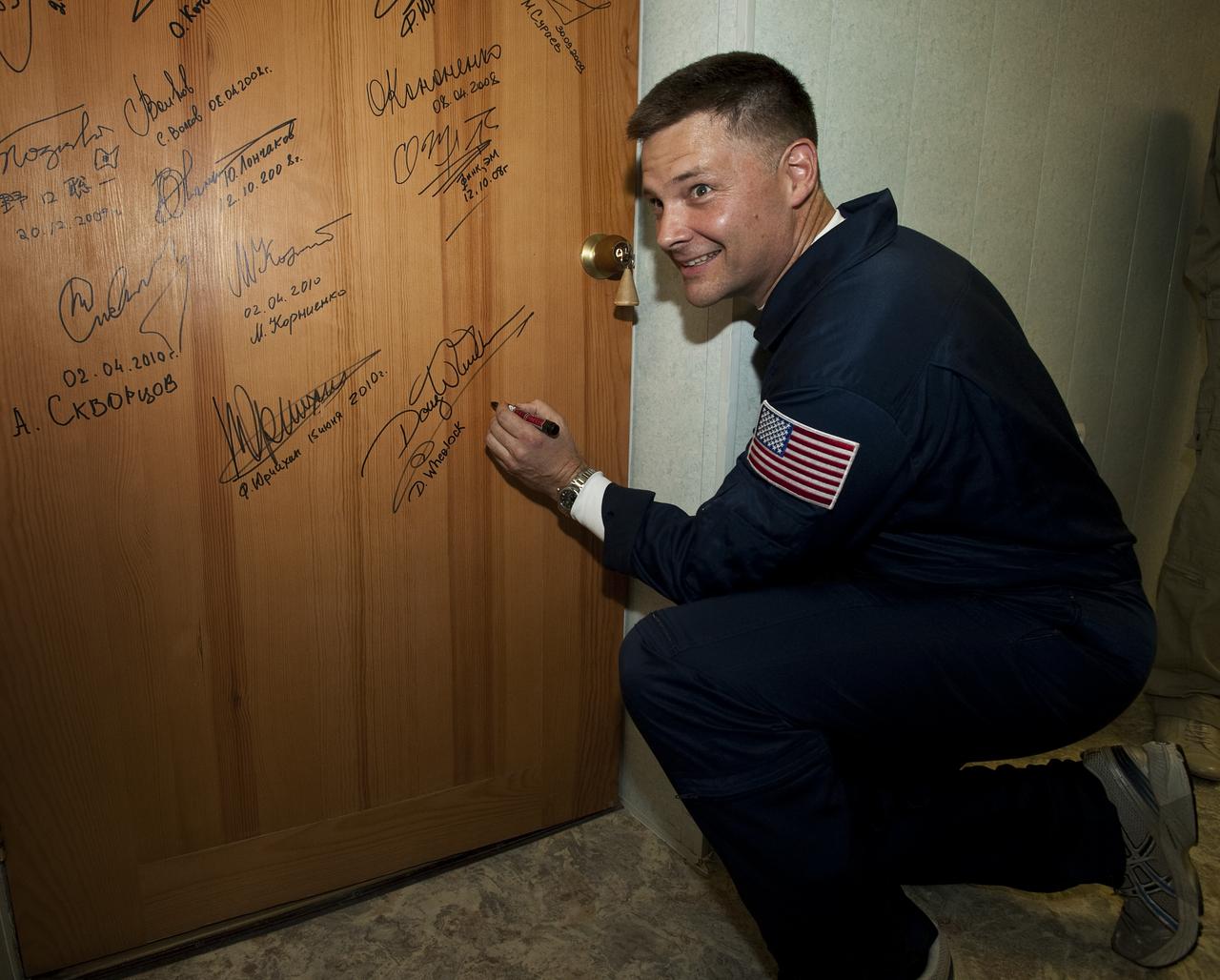 Expedition 24 Flight Engineer Doug Wheelock performs the traditional door signing prior to his launch to the International Space Station, Tuesday, June 15, 2010 at the Cosmonaut Hotel in Baikonur, Kazakhstan. Wheelock was launched onboard the Soyuz rocket the following morning with Expedition 24 Flight Engineer Shannon Walker and Soyuz Commander Fyodor Yurchikhin on a mission to the ISS.  Photo Credit: (NASA/Carla Cioffi)