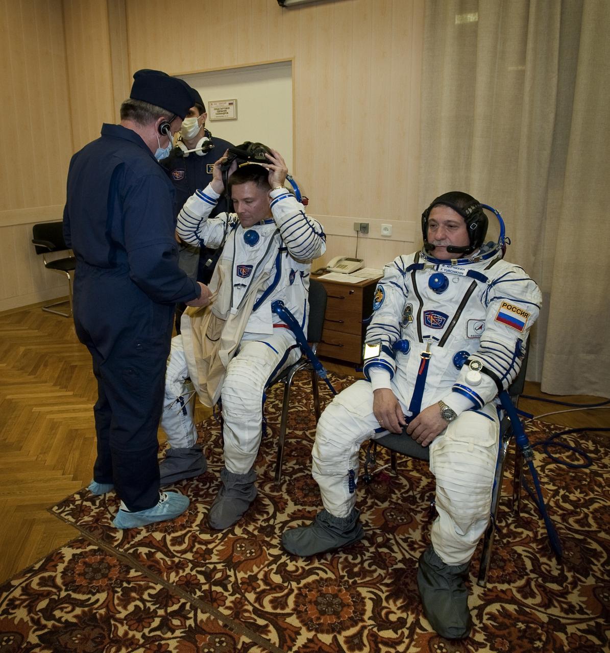 Expedition 24 NASA Flight Engineer Doug Wheelock, left, of the U.S. and Soyuz Commander Fyodor Yurchikhin have their Russian Sokol suits prepared for launch by a technician at the Baikonur Cosmodrome in Baikonur, Kazakhstan, Tuesday, June 15, 2010. Wheelock, Yurchikhin and Flight Engineer Shannon Walker launched in their Soyuz TMA-19 rocket from the Baikonur Cosmodrome in Kazakhstan on Wednesday, June 16, 2010. (Photo Credit: NASA/Carla Cioffi)