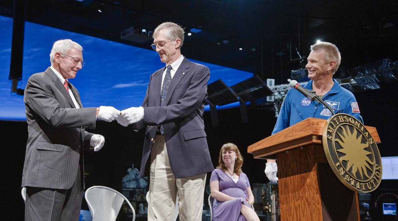 Dr. John Mather, NASA Goddard Space Flight Center scientist and Nobel Laureate, center, presents Gen. John R. “Jack” Dailey, director of the Smithsonian National Air and Space Museum, left, with a a replica of Mather’s Nobel Prize medal that flew in space aboard STS-132, as astronaut Piers Sellers looks on, during a ceremony at the museum, Tuesday, July 27, 2010, in Washington.  Photo Credit: (NASA/Paul E. Alers)