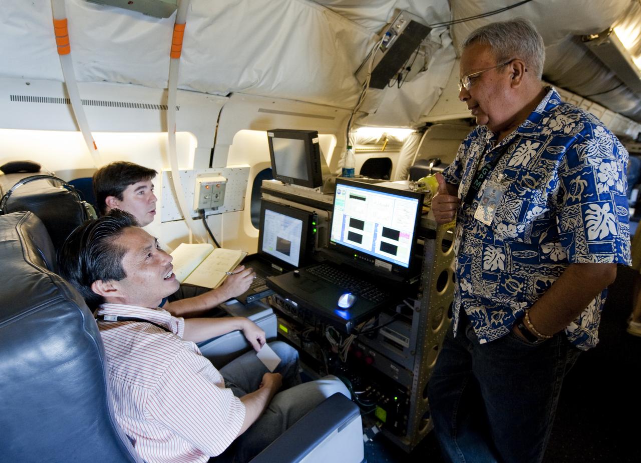 Jeffrey Beyon, lower right, and Paul Joseph Petzar, right, researchers from NASA's Langley Research Center, speak with Ramesh Kakar right, of the NASA Earth Science Division as they work with DAWN Air Data  Acquisition and Processing software aboard NASA's DC-8 research aircraft, Sunday, Aug. 15, 2010, in support of the GRIP experiment at Fort Lauderdale International Airport in Fort Lauderdale, Fla.  The Genesis and Rapid Intensification Processes (GRIP) experiment is a NASA Earth science field experiment in 2010 that is being conducted to better understand how tropical storms form and develop into major hurricanes. Photo Credit: (NASA/Paul E. Alers)